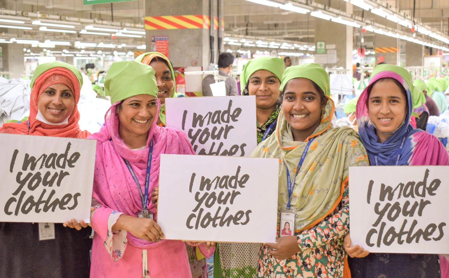 Bildquelle: Stanley & Stella: Textilarbeiterinnen in Bangladesch zeigen voller Stolz Schilder der Fashion Revolution Kampagne "I made your clothes". Sie sind die wahren Heldinnen hinter unserer Kleidung.