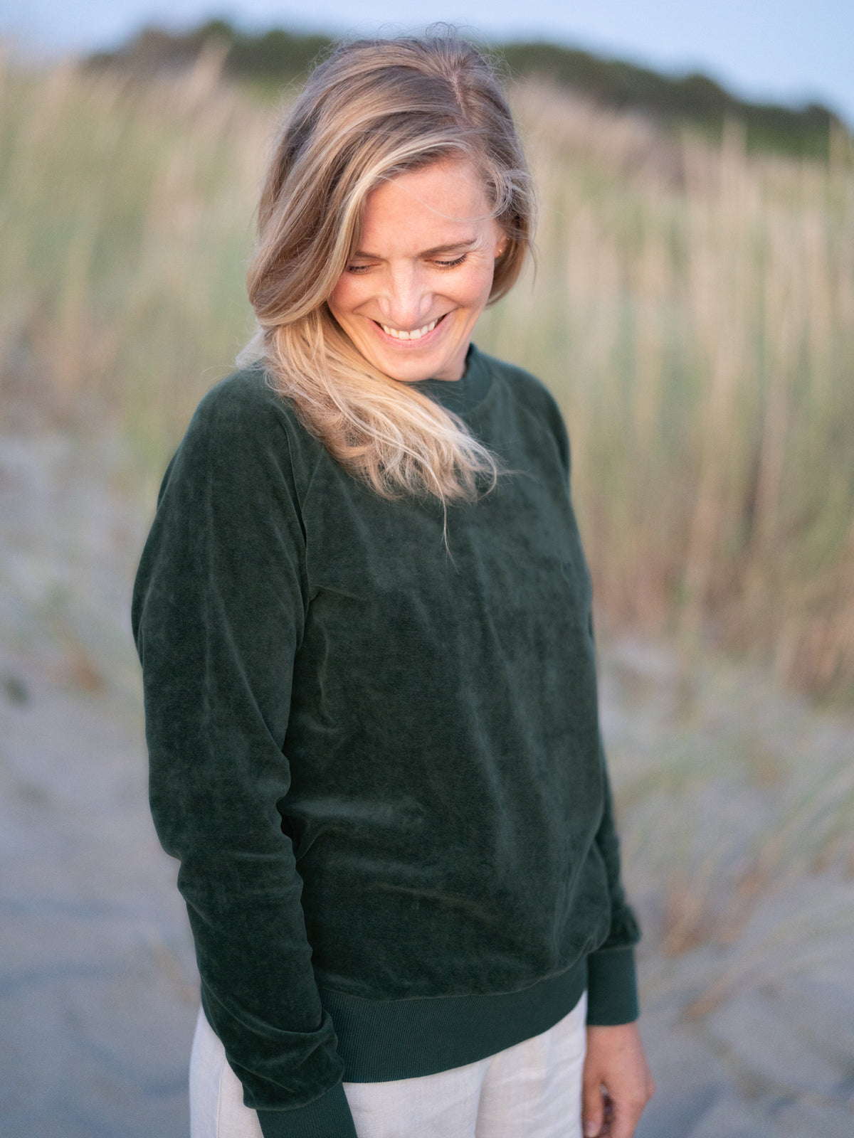 FUXBAU Frauen Samt Sweater in grün aus 100% GOTS zertifizierter Biobaumwolle made in Portugal. Isi ist 1,68m und trägt "M"