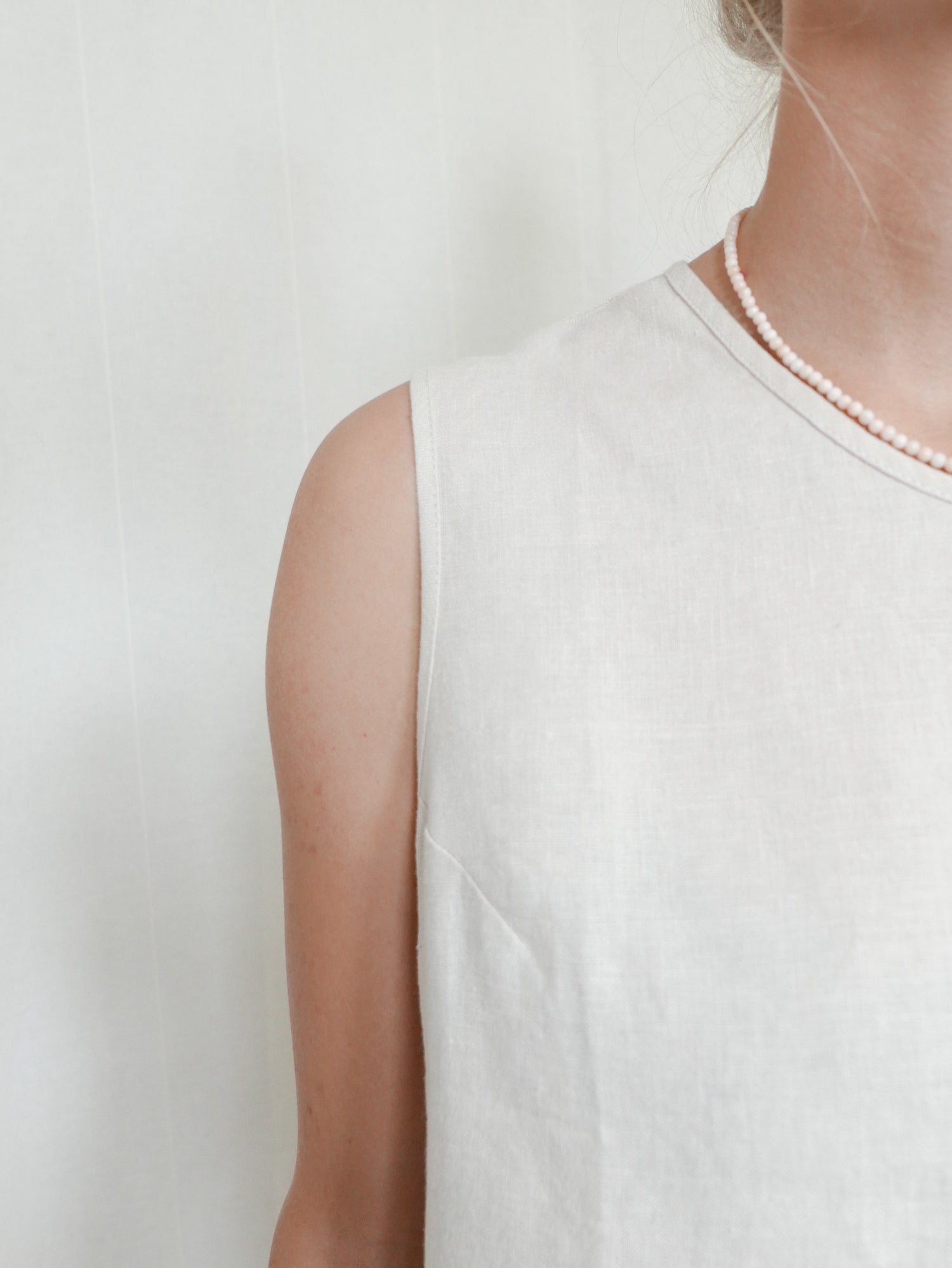 Greta trägt das Fair Fashion FUXBAU Leinentop in cremeweiß für Frauen von FUXBA, perfekt für die warmen Tage, 100% Leinen & Made in Portugal