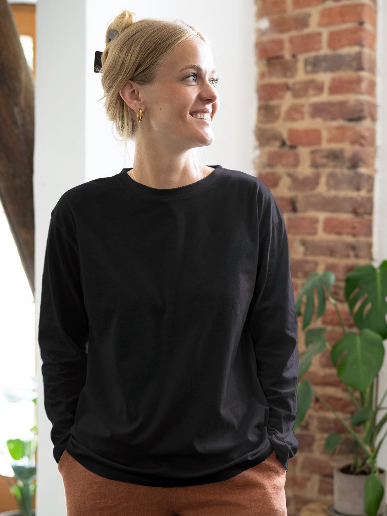Greta trägt das nachhaltige und faire Frauen Basic Langarmshirt in schwarz aus 100% GOTS zertifizierter Biobaumwolle made in Portugal