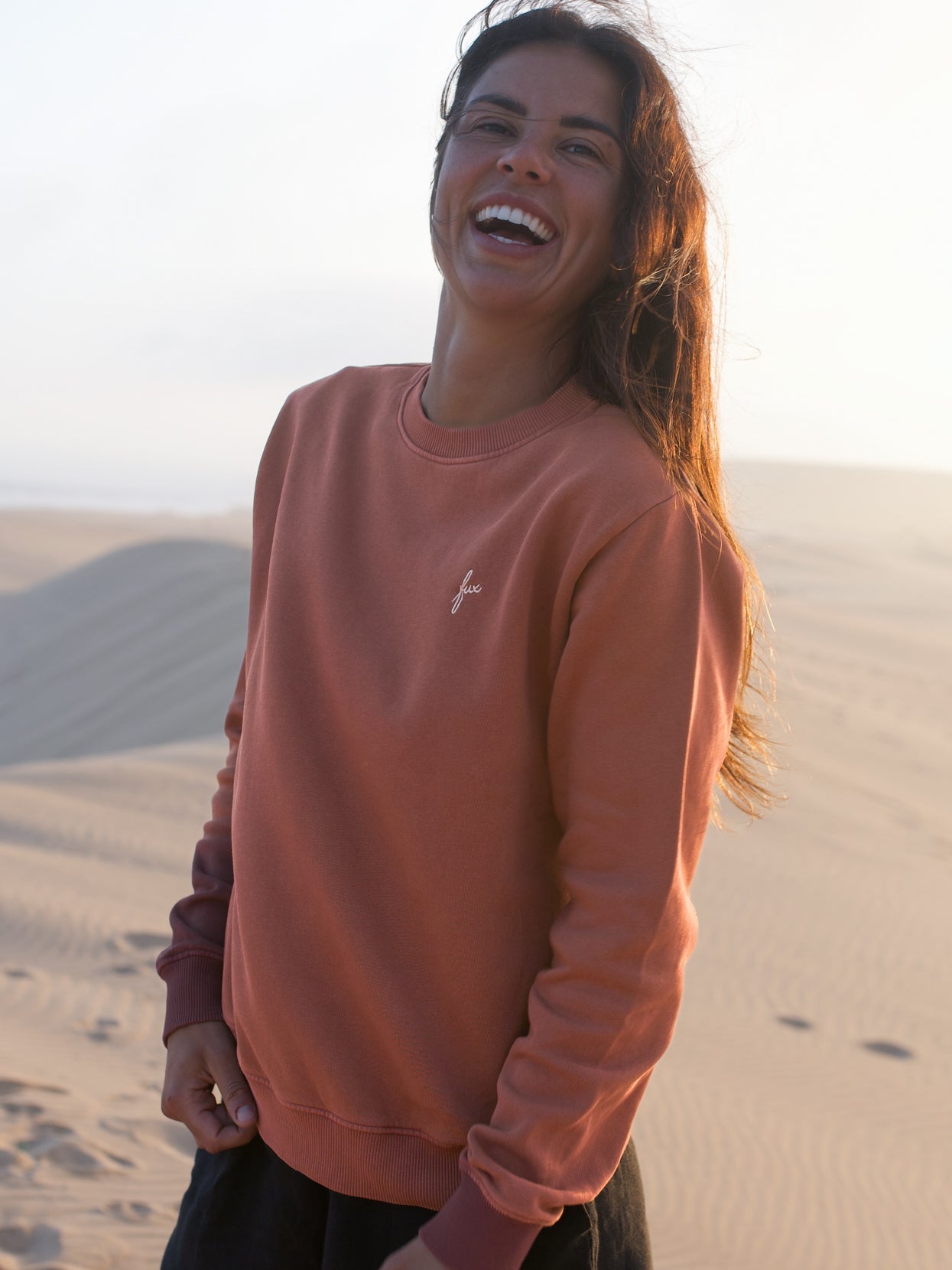 Roter Frauen Pullover von FUXBAU im Vintage Look aus Bio-Baumwolle vor heller Dünenlandschaft