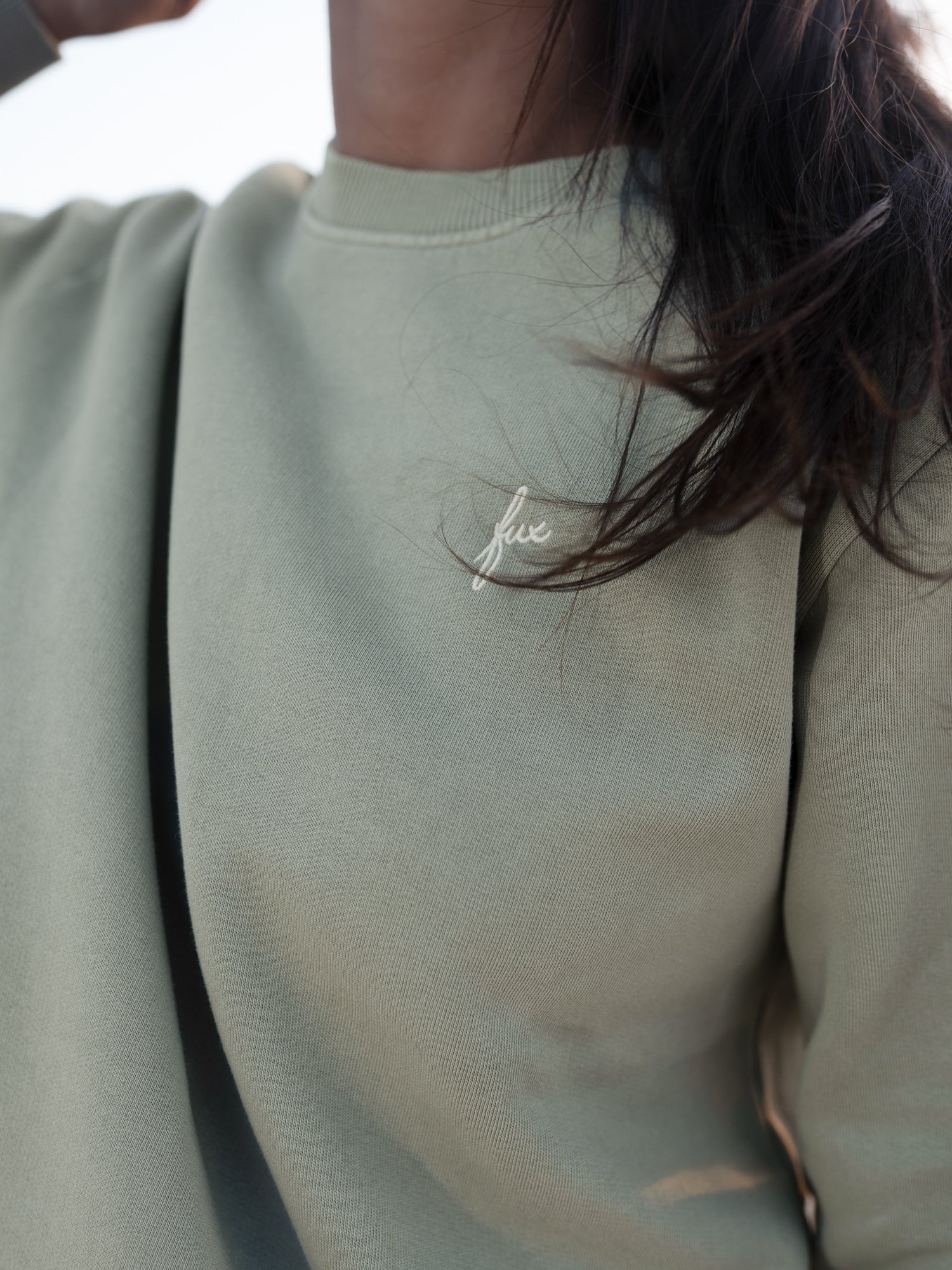 Detailaufnahme vom seegrünen FUXBAU Frauen Pullover aus Biobaumwolle mit dezentem Stick