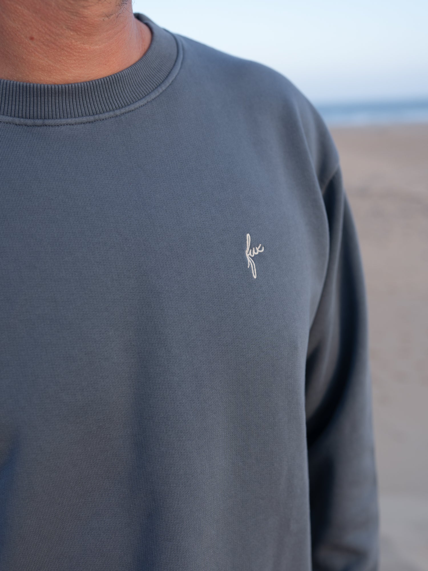 Seeblauer FUXBAU Männer Pullover im Vintage Look mit dezentem Stick am Strand
