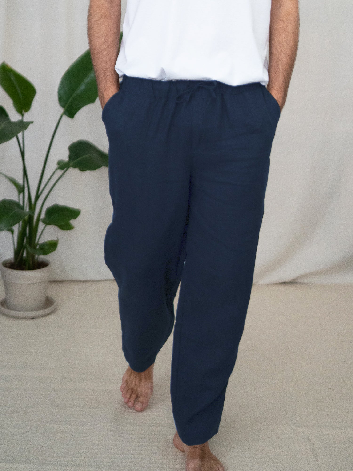 Philipp trägt die nachhaltige lockere Leinenhose in navy von FUXBAU aus 100% Leinen