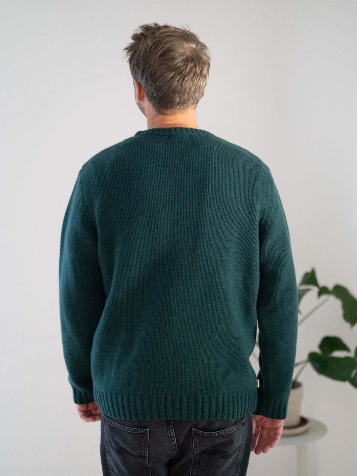 Männer Strickpullover grün aus 100% Merinowolle, gestrickt in Deutschland – seitliche Ansicht mit Rundhalsausschnitt und Rippbündchen