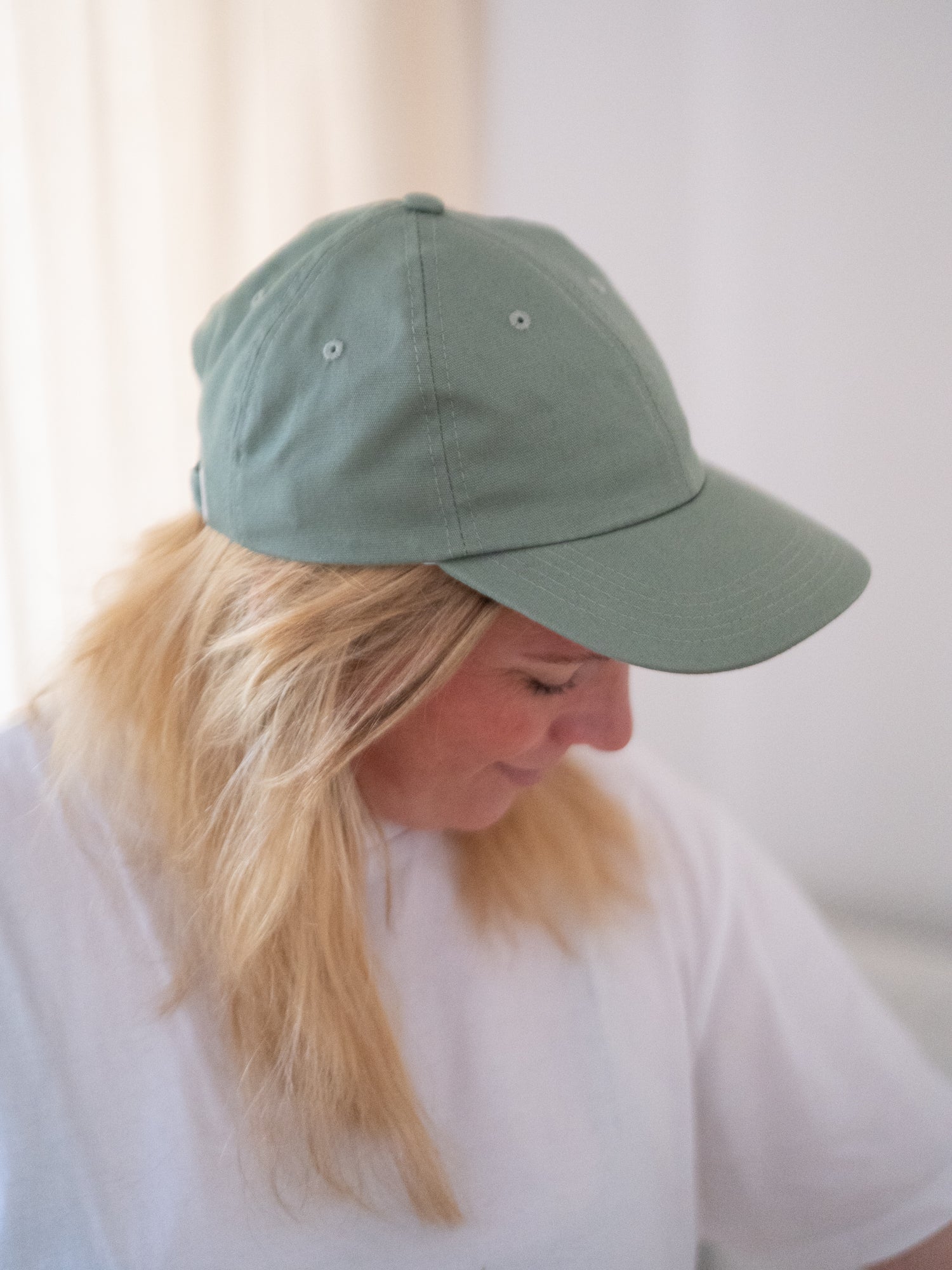 Unisex Dad Cap in hellgrün aus 100% Biobaumwolle und fair in Europa hergestellt, getragen von einer blonden Frau