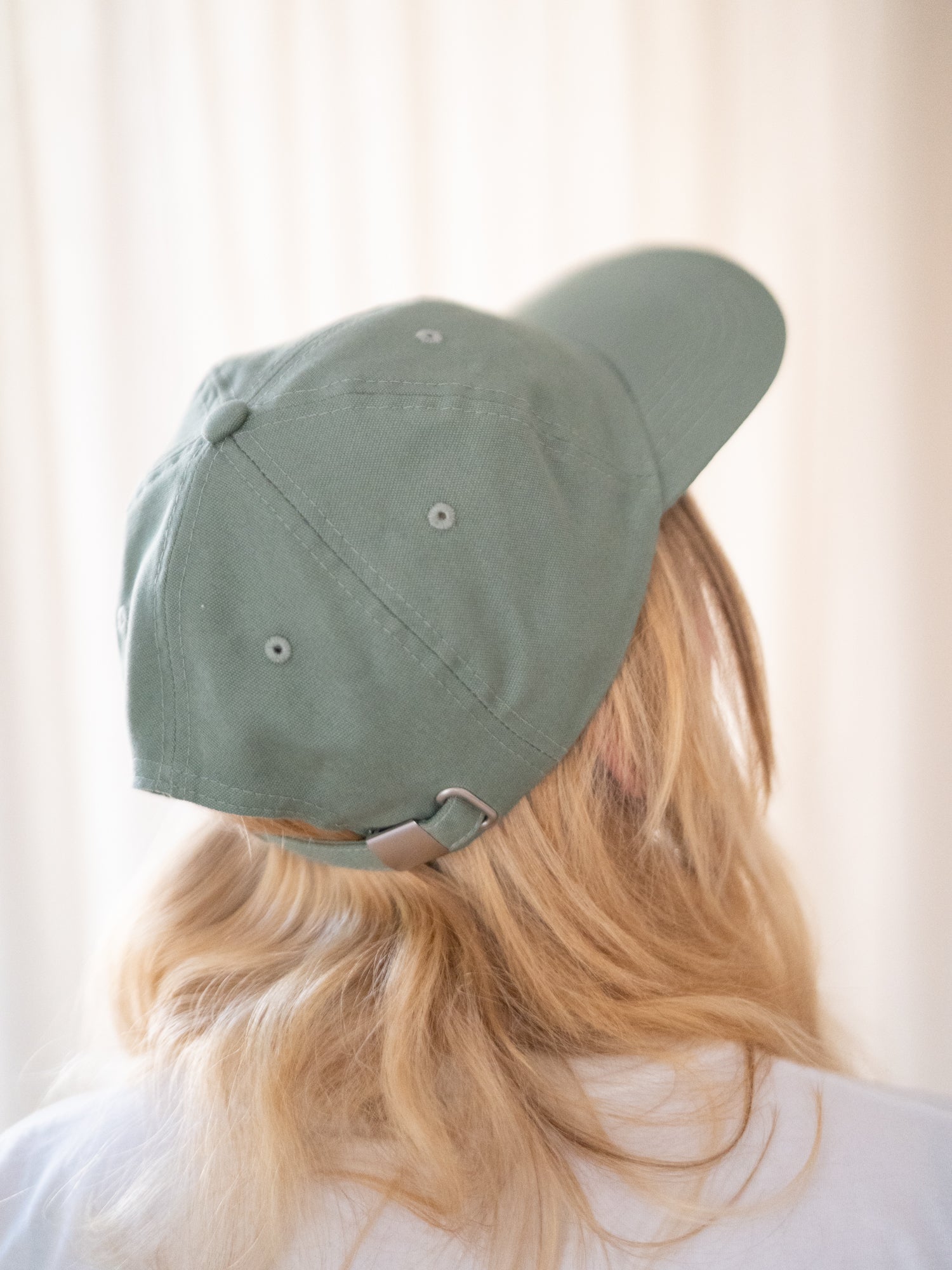 Unisex Dad Cap in hellgrün getragen von einer blonden Frau