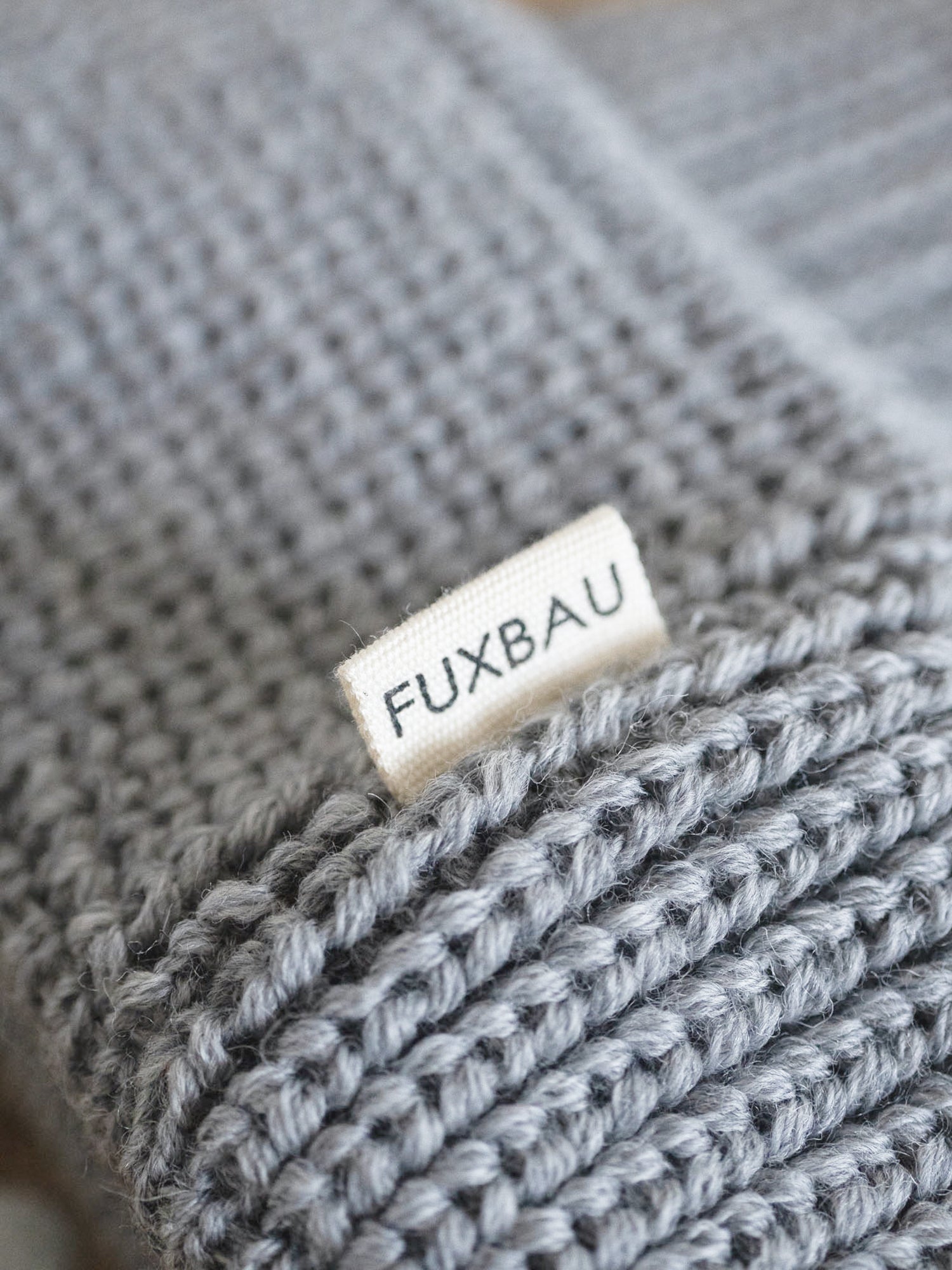 Detailaufnahme der FUXBAU Sideflag der kurzen Merino Fischermütze in graumeliert, GOTS zertifiziert und made in Germany