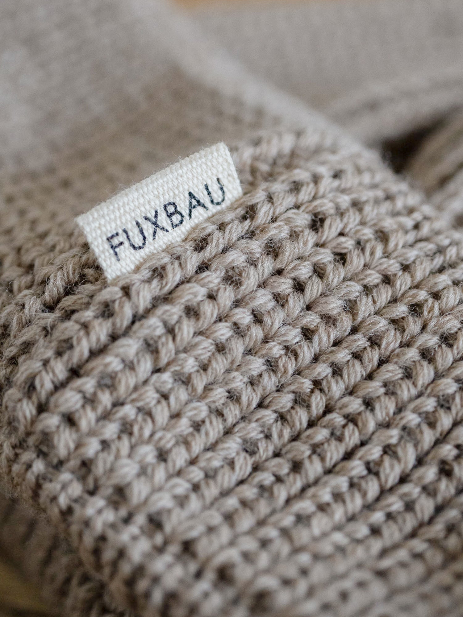 Detailaufnahme der FUXBAU Sideflag der kurzen Merino Fischermütze in sand, GOTS zertifiziert und made in Germany