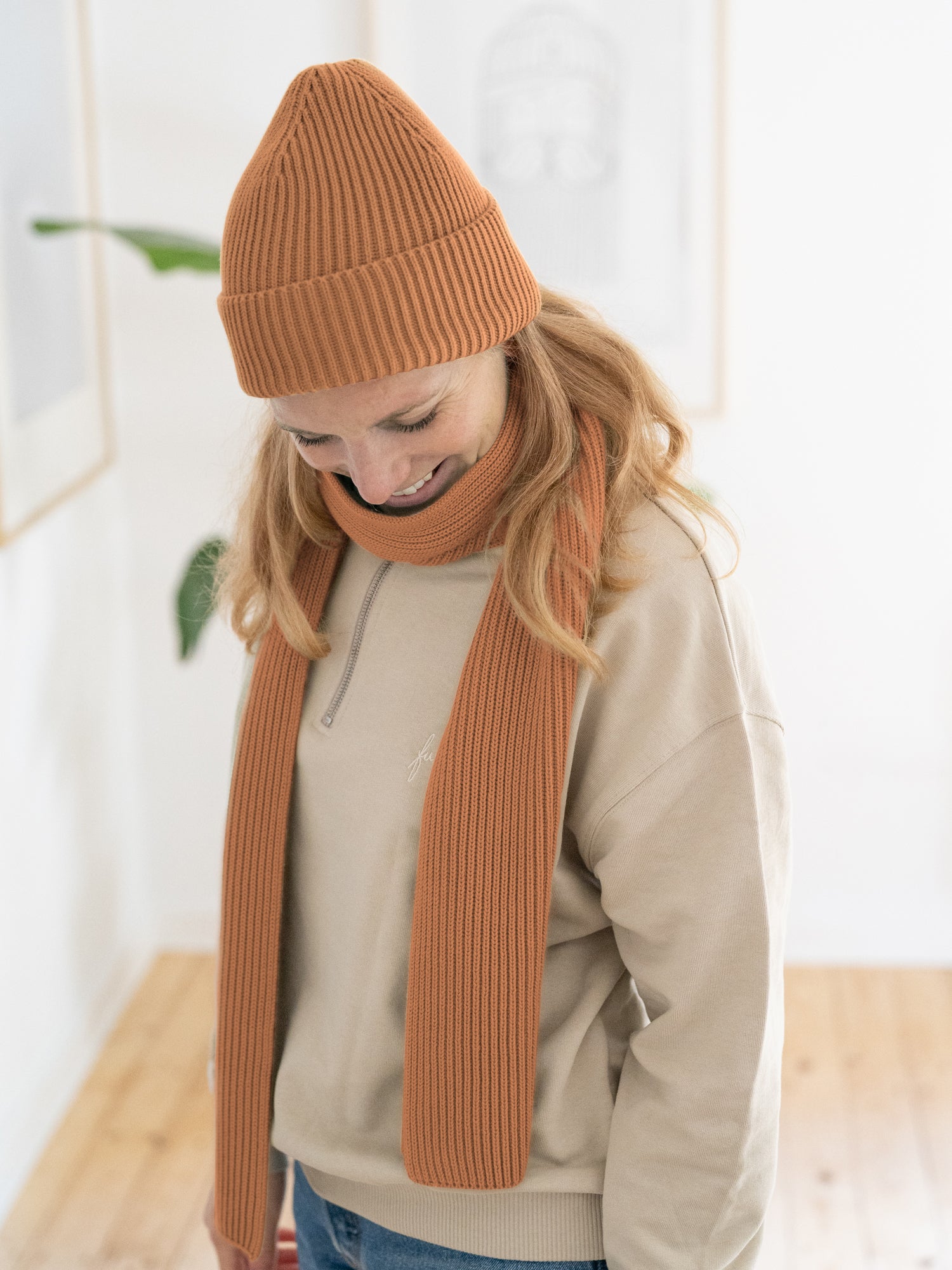 Isi trägt das FUXBAU Eco Bundle 4Seasons Strickmütze und Strickschal in rostbraun aus 100% GOTS zertifizierter Biobaumwolle.