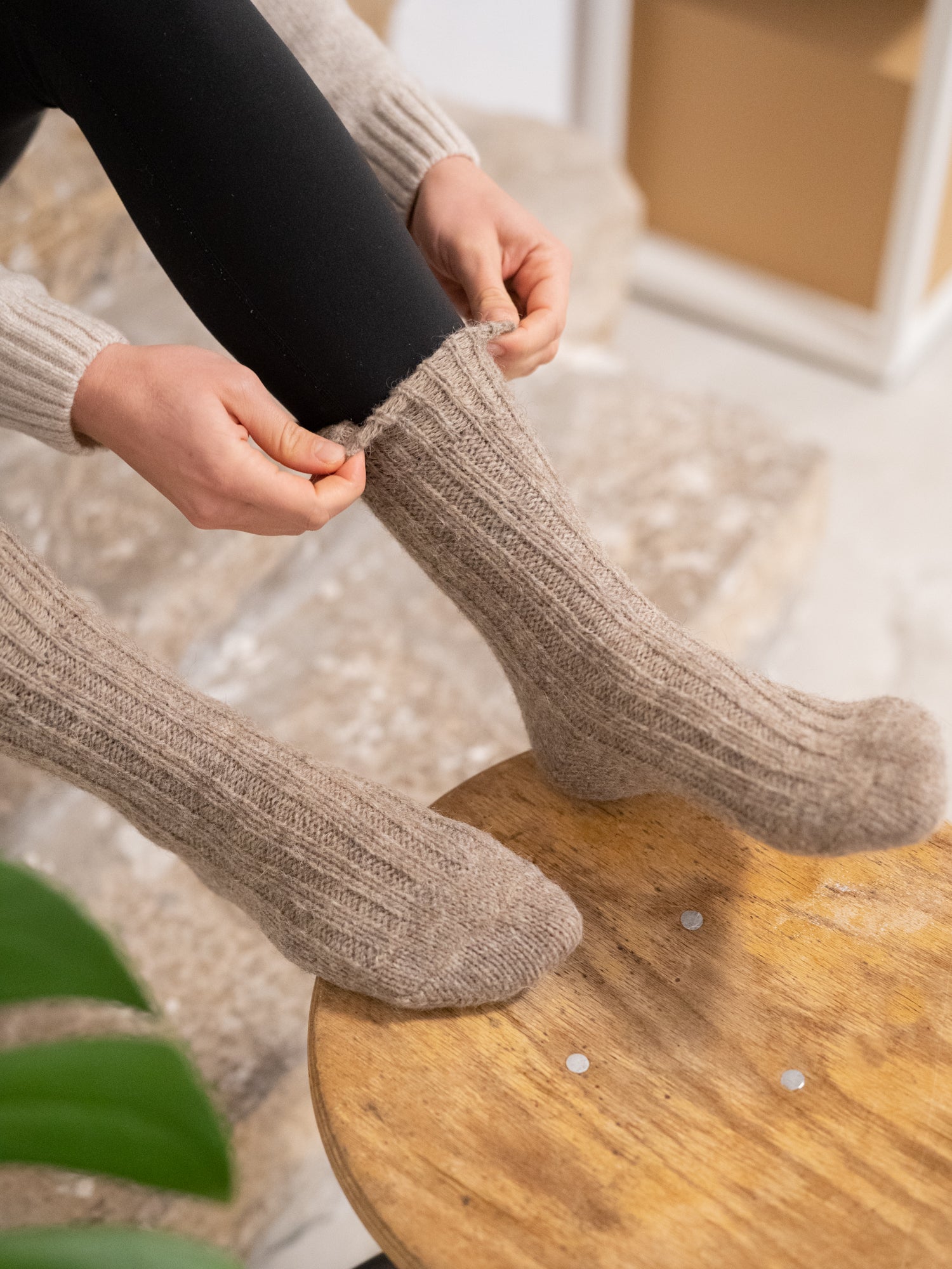 Greta trägt unsere warmen und weichen Alpaka Schafwollsocken in beige aus Alpaka und europäischer Schafwolle.