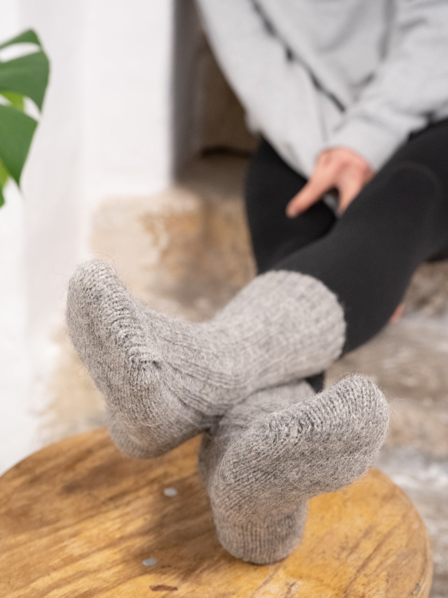 Greta trägt unsere warmen und weichen Alpaka Schafwollsocken in grau aus Alpaka und europäischer Schafwolle.