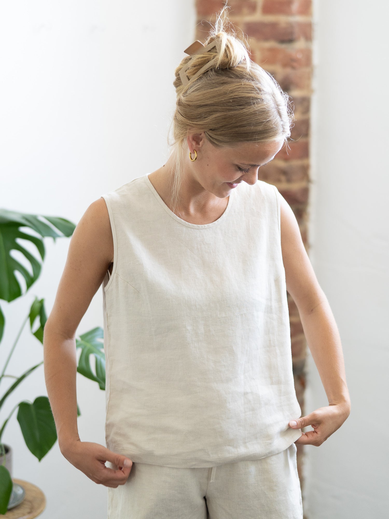 Luftiges Leinentop in cremeweiß für Frauen von FUXBAU, perfekt für die warmen Tage, 100% Leinen & Made in Portugal. Getragen von einer jungen, blonden Frau.