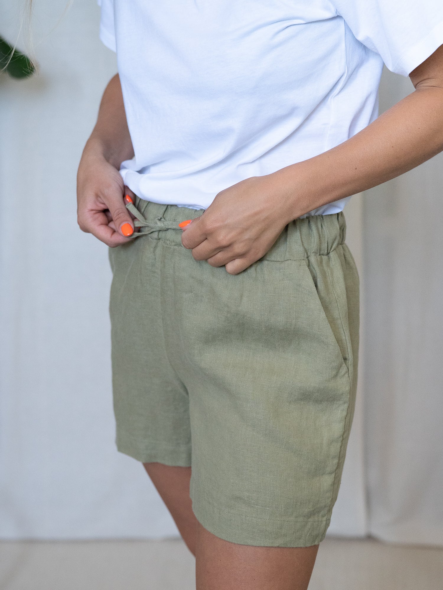 Nachhaltige Fair Fashion Frauen Leinenshorts von FUXBAU in Farbe salbei hellgrün aus 100% Leinen. Getragn von einer jungen, blonden Frau in Größe "S".