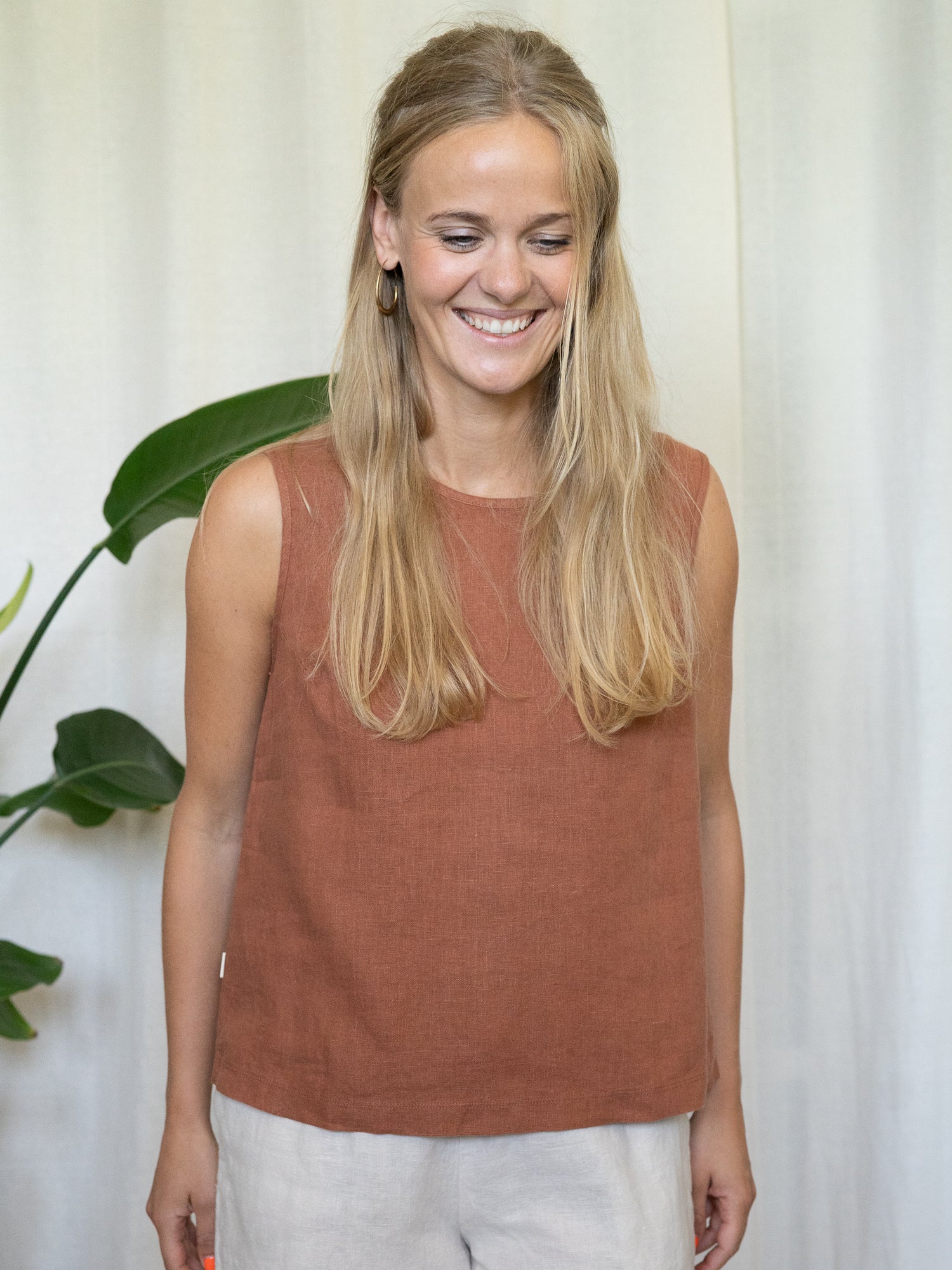 Frau trägt ärmelloses Leinentop in Rostbraun – nachhaltige Sommermode aus 100 % Leinen von FUXBAU, fair produziert in Europa, perfekt für heiße Tage