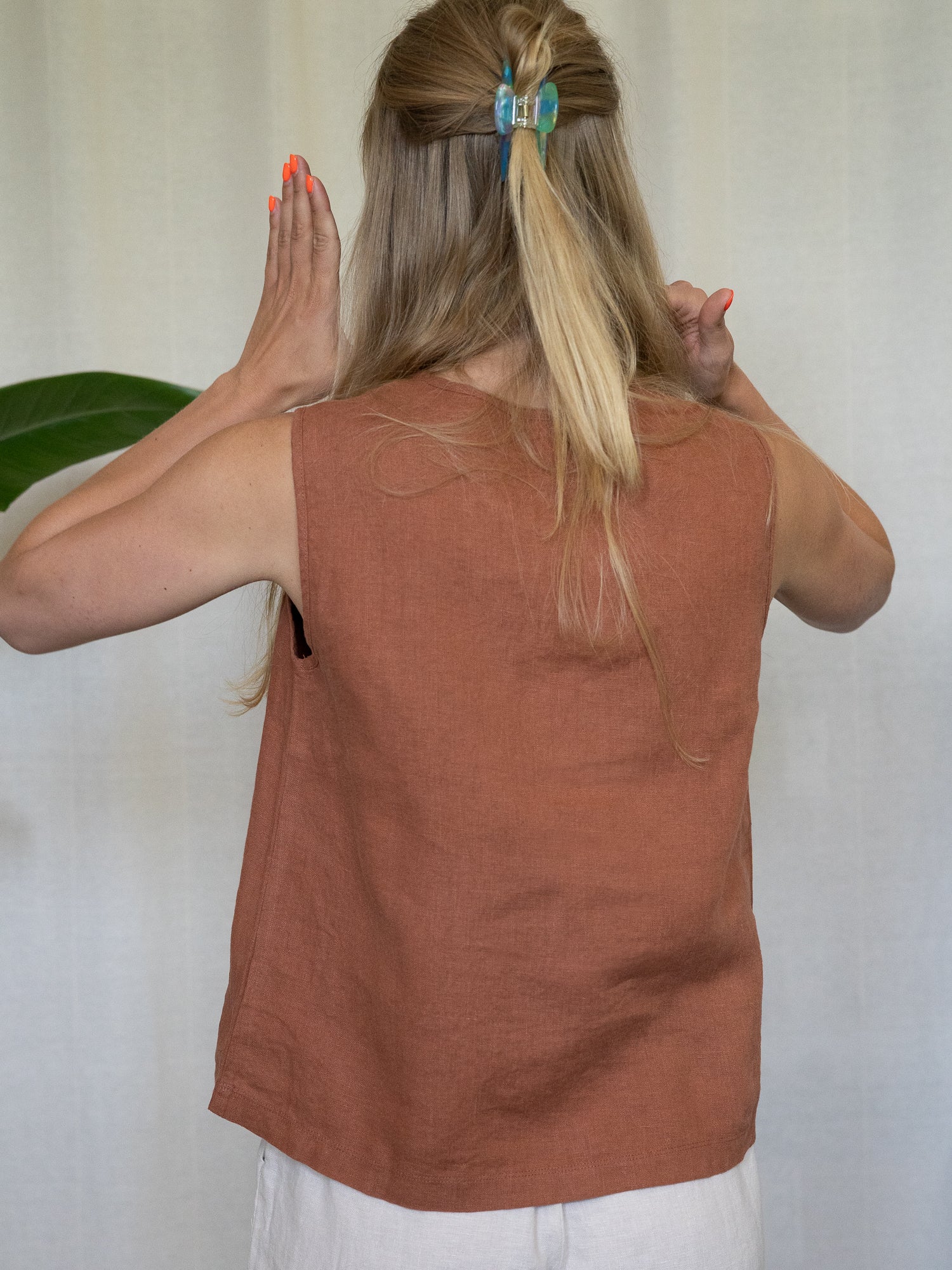 Frau trägt ärmelloses Leinentop in Rostbraun – nachhaltige Sommermode aus 100 % Leinen von FUXBAU, fair produziert in Europa, perfekt für heiße Tage