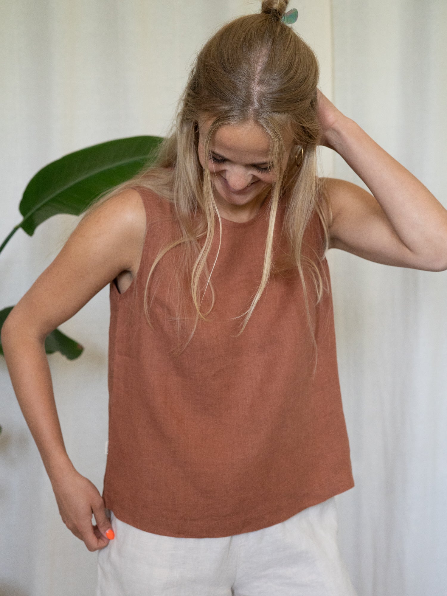 Frau trägt ärmelloses Leinentop in Rostbraun – nachhaltige Sommermode aus 100 % Leinen von FUXBAU, fair produziert in Europa, perfekt für heiße Tage