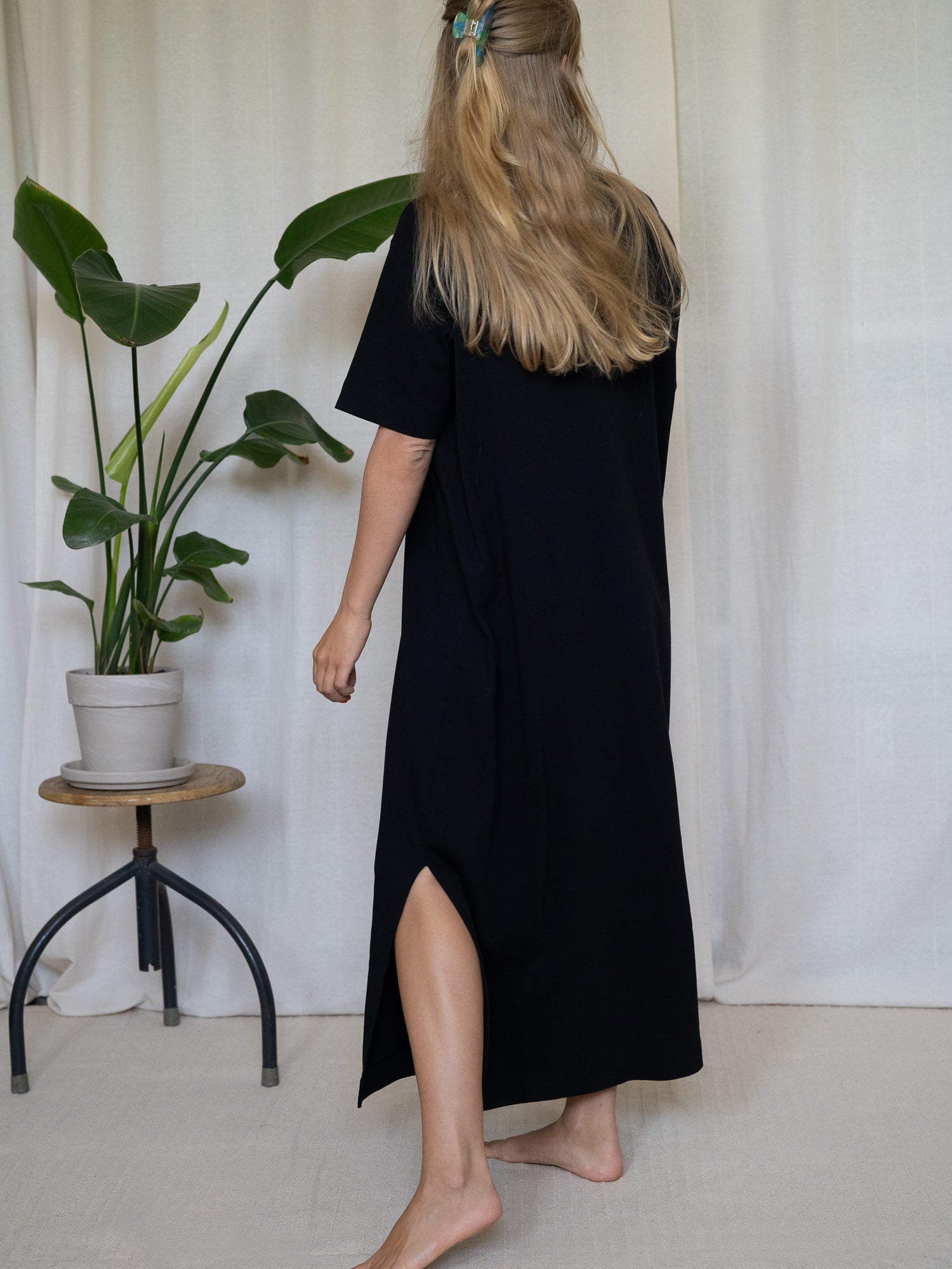 Schwarzes FUXBAU Midikleid aus GOTS-zertifizierter Biobaumwolle – Rückansicht mit seitlichem Schlitz, fair gefertigt in Portugal.