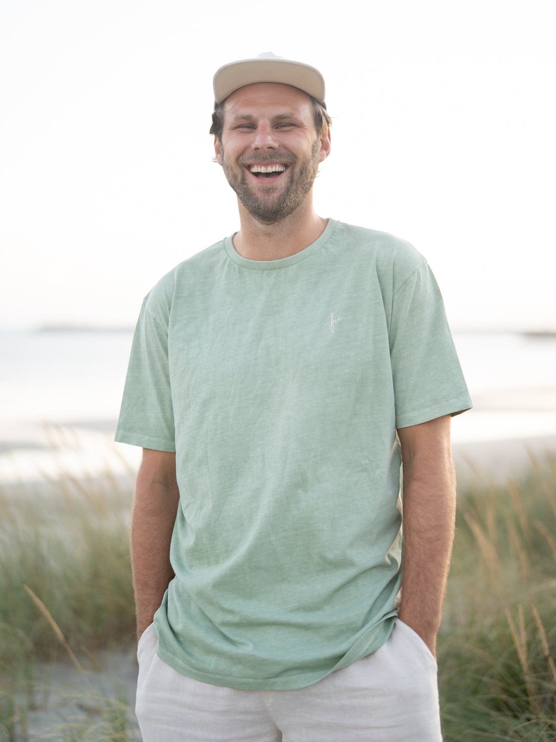 Natürliche Färbung und 100% GOTS zertifizierte Biobaumwolle, Philipp trägt das FUXBAU Männer Natural dye T-Shirt in grün.