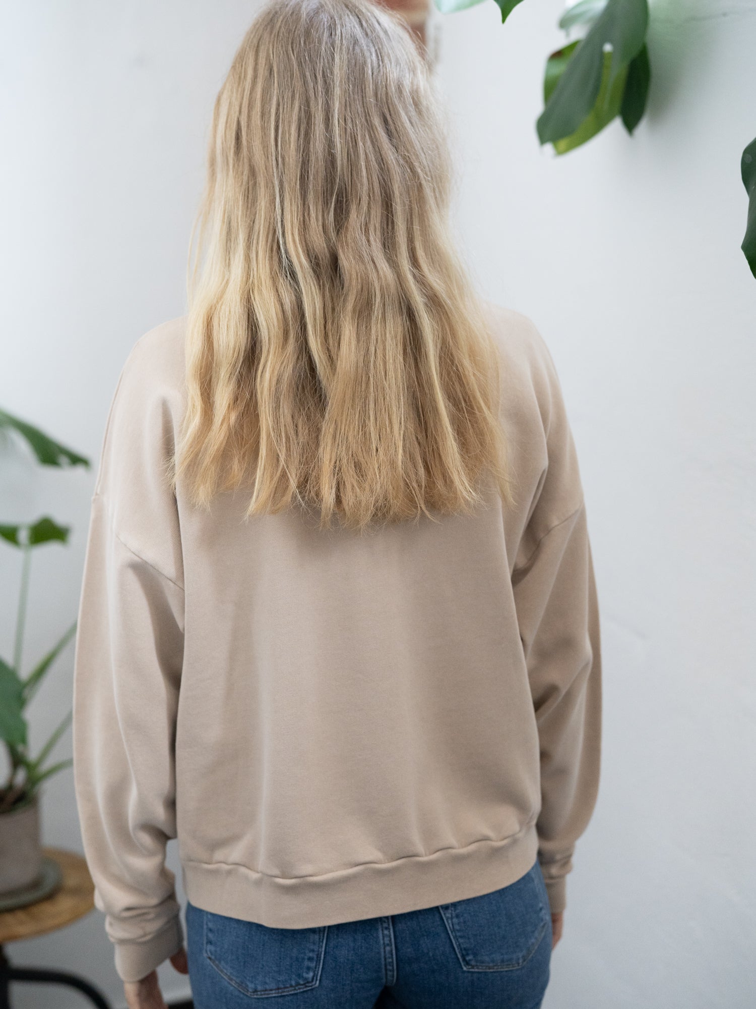 Nachaltiger Fair Fashion Oversize Pulloer von FUXBAU in beige, gefärbt mit naturfarben und getragen von einer jungen blonden Frau.