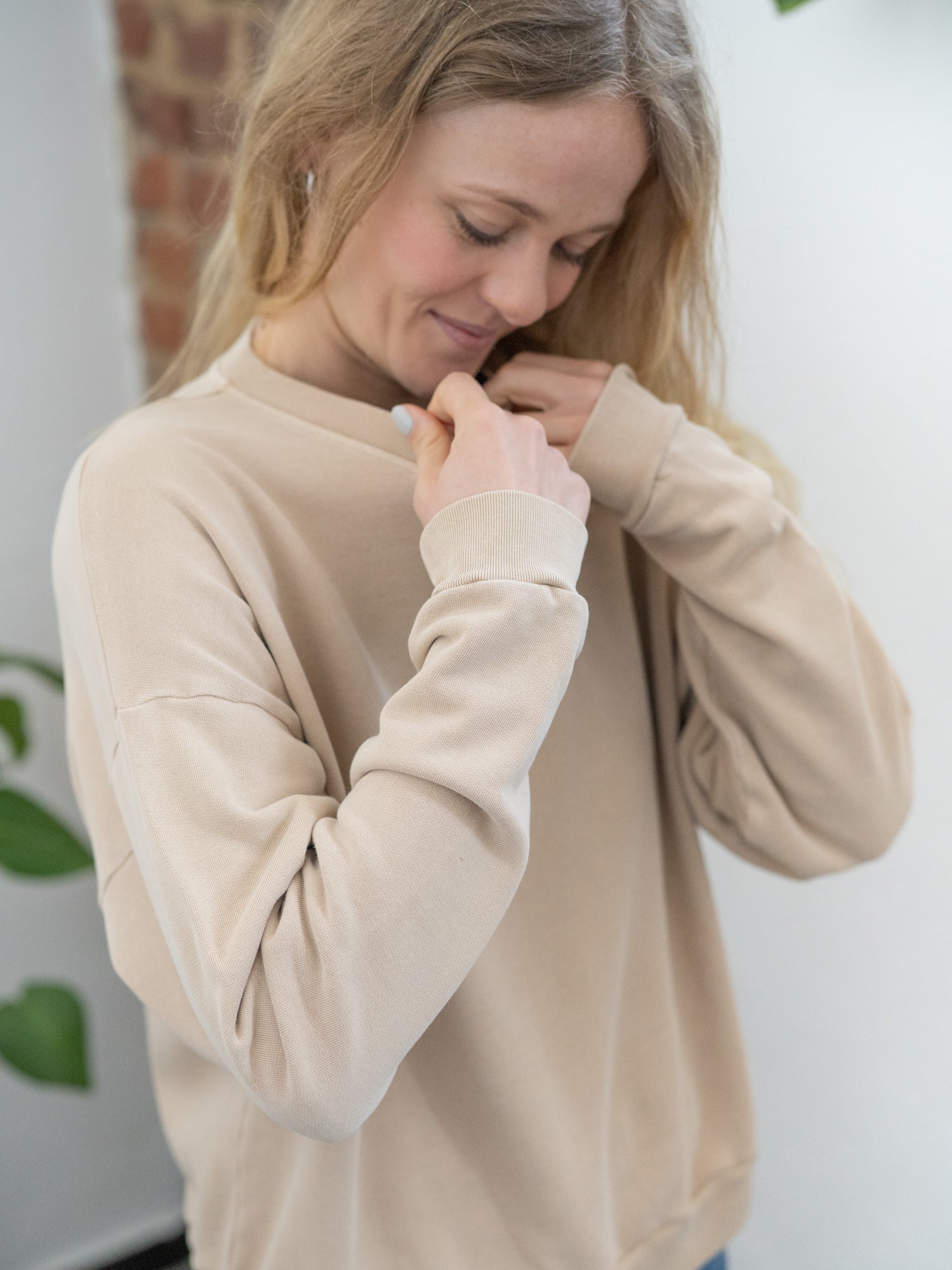 Nachaltiger Fair Fashion Oversize Pulloer von FUXBAU in beige, gefärbt mit naturfarben und getragen von einer jungen blonden Frau.