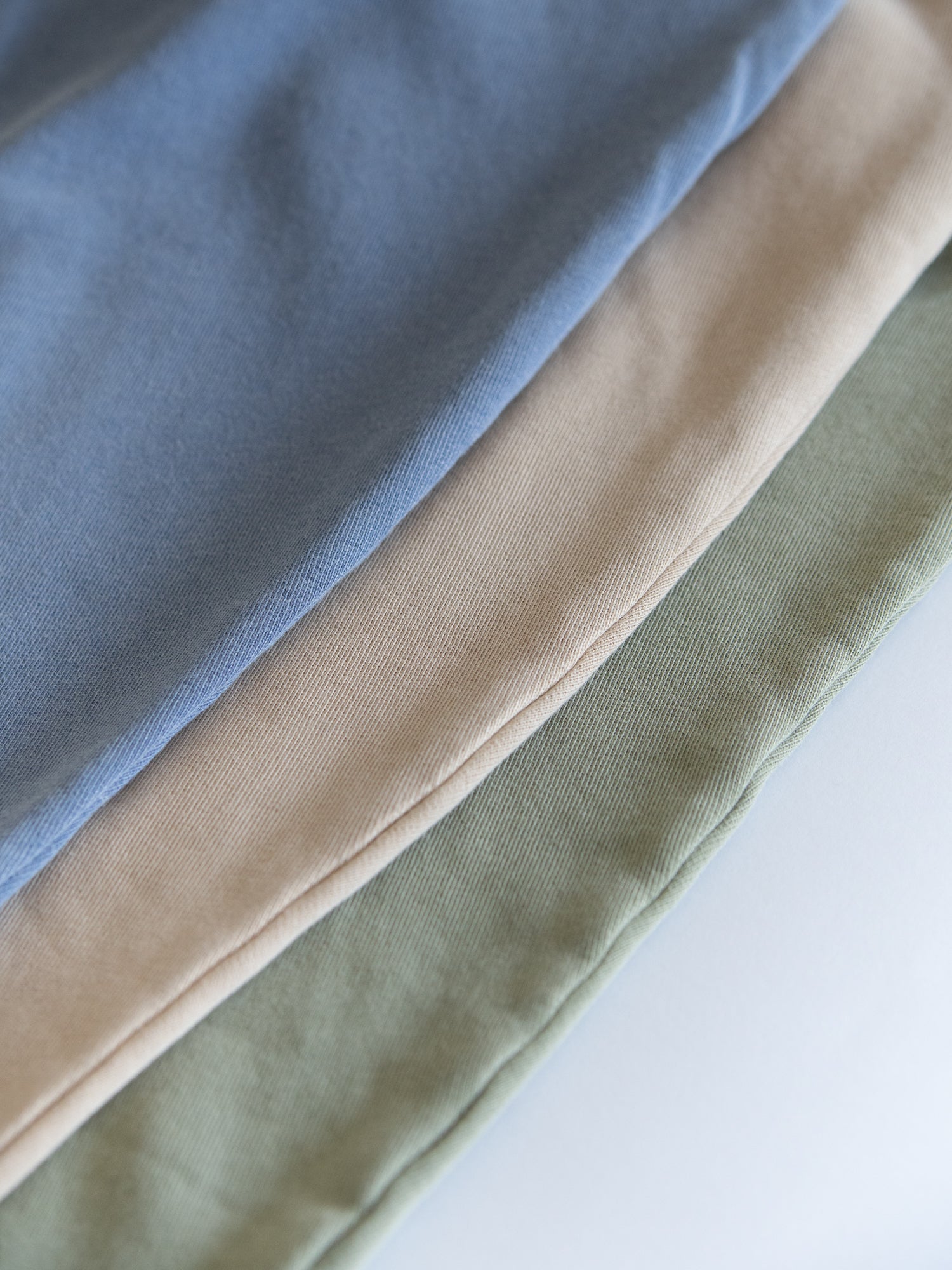 Detailansicht eines blauen, beigen und grünen Fair Fashion Frauen Oveersize Pullover, gefärbt mit Naturfarben in Portugal aus 100 Baumwolle.