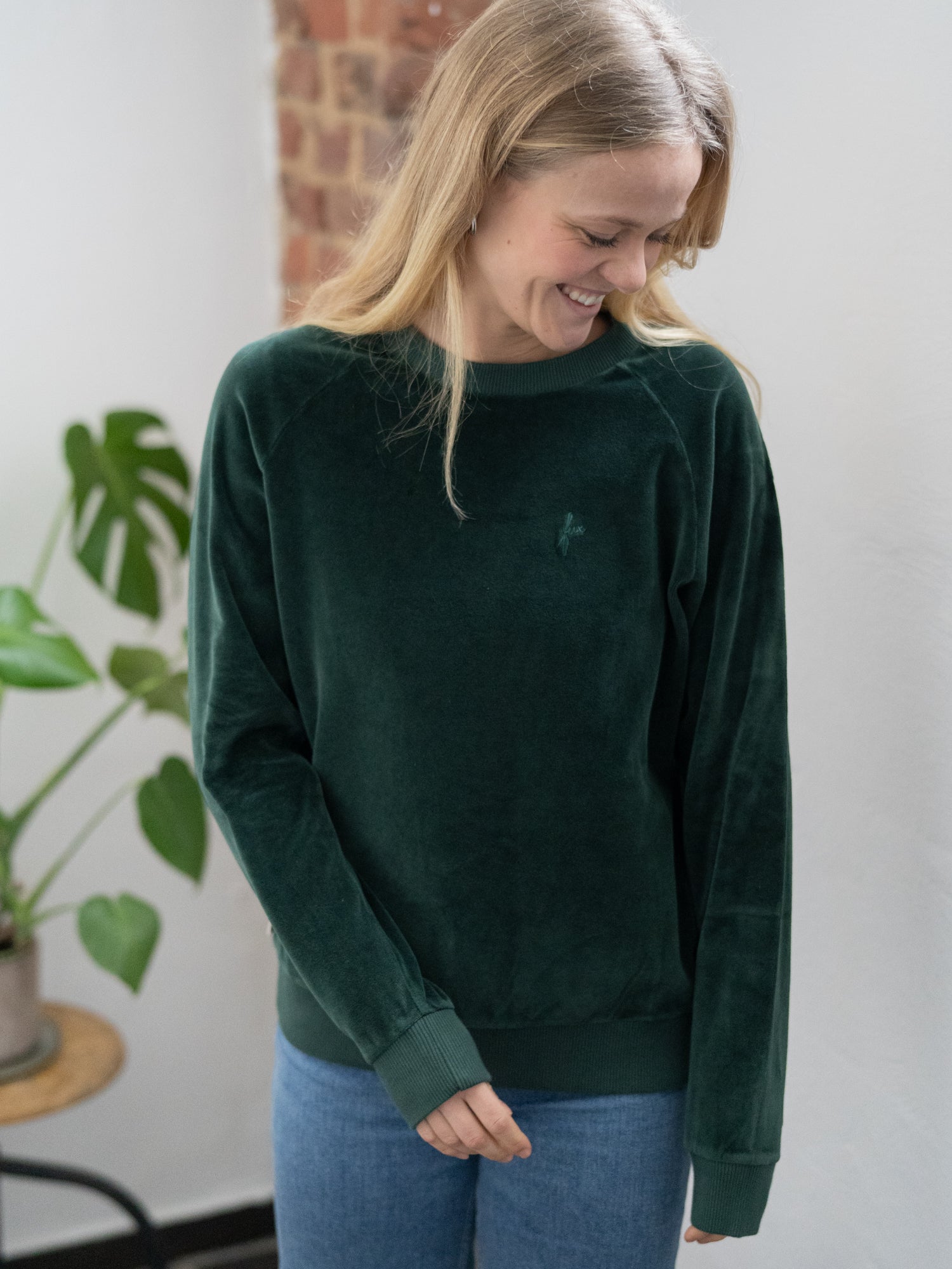 Fair Fashion FUXBAU Frauen Samt Sweater in grün aus 100% GOTS zertifizierter Biobaumwolle made in Portugal. Getragen von Greta bei uns im Ladenbüro in Münster.