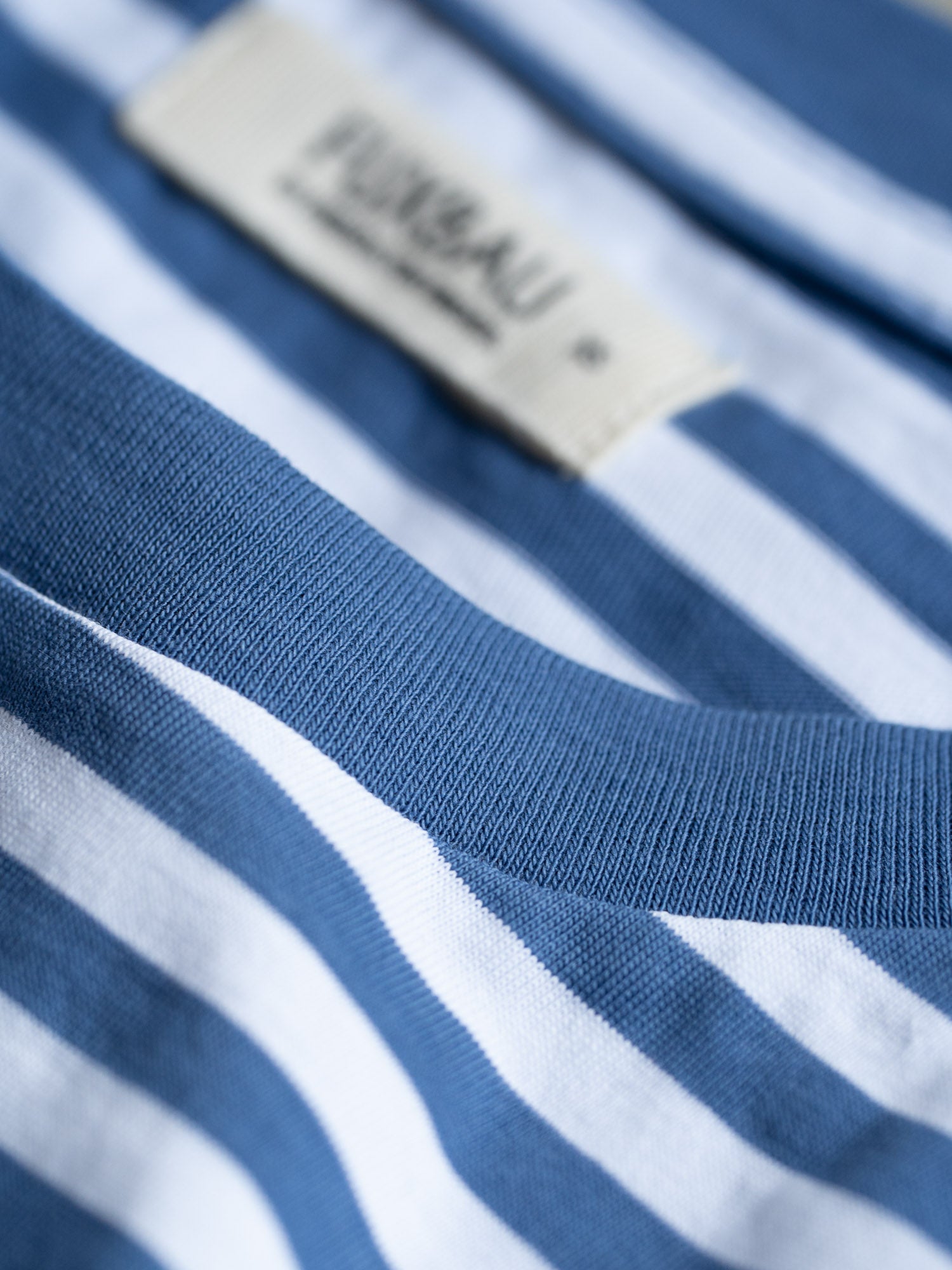 Detailansicht eines T-Shirt Kragen mit blau weiss gestreiften Streifen aus Biobaumwolle von FUXBAU.