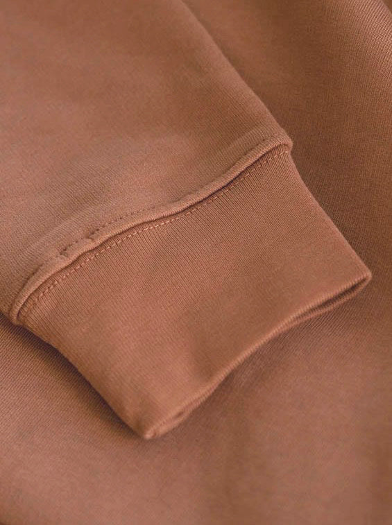 Hochwertige Ärmel in braun eines nachhaltig und fair produzierten FUXBAU Hoodies in braun karamell.