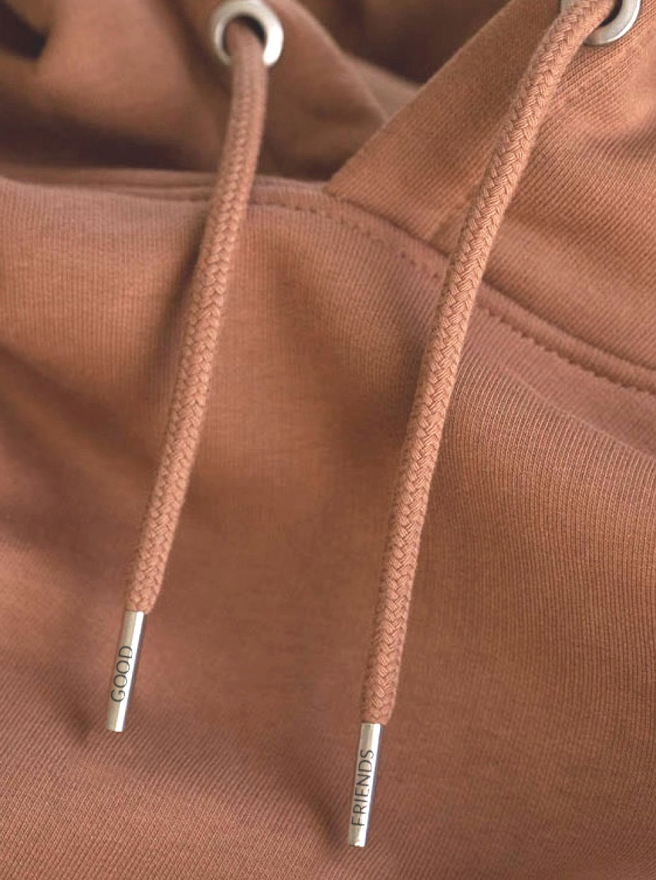 Veredelung unserer nachhaltigen Hoodies mit Good Friends Metallenden der Kordeln