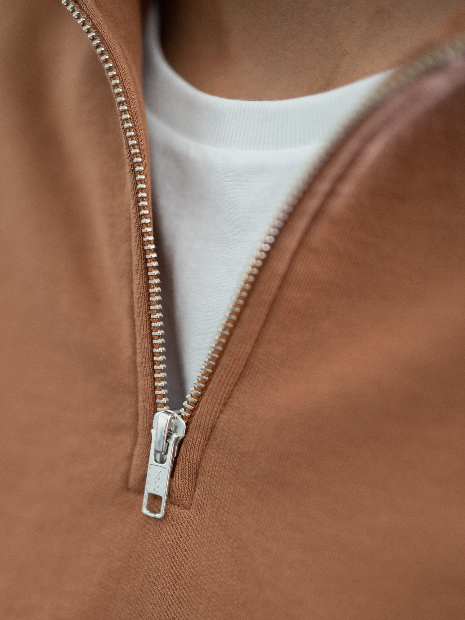 Nachhaltiger Fair Fashion Männer Half Zip Sweater in Karamell von FUXBAU. Gefertigt aus 100% GOTS zertifizierter Biobaumwolle in Portugal. Detailansicht eines YKK Reissverschluss.