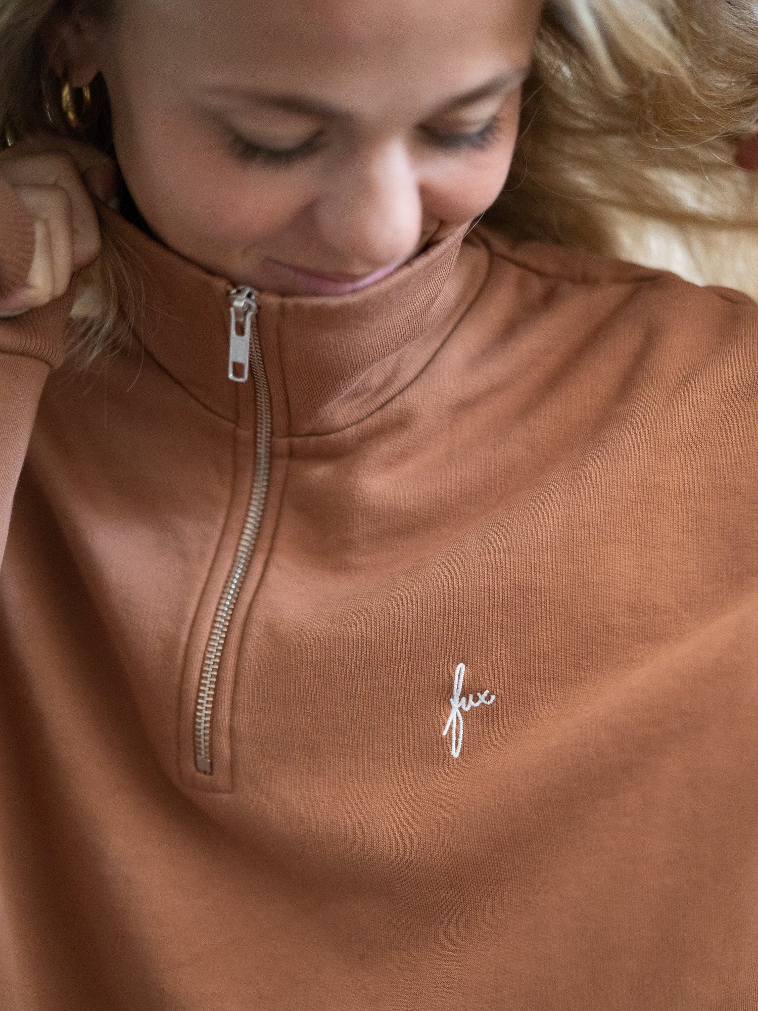 Nachhaltiger Fair Fashion Frauen Half Zip Sweater in karamell von FUXBAU. Gefertigt aus 100% GOTS zertifizierter Biobaumwolle in Portugal. Getragen von einer jungen, blonden Frau.