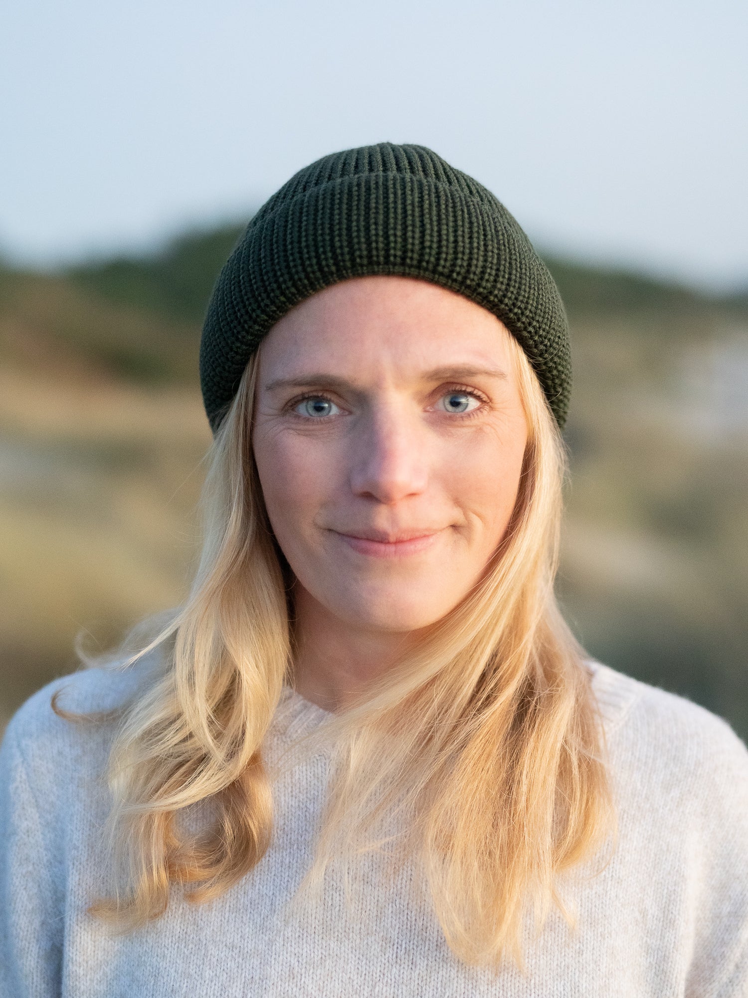 Unsere Freundin Isi trägt die Kurze Merino Strickmütze in waldgrün von FUXBAU aus 100% GOTS zertifizierter Merinowolle made in Germany