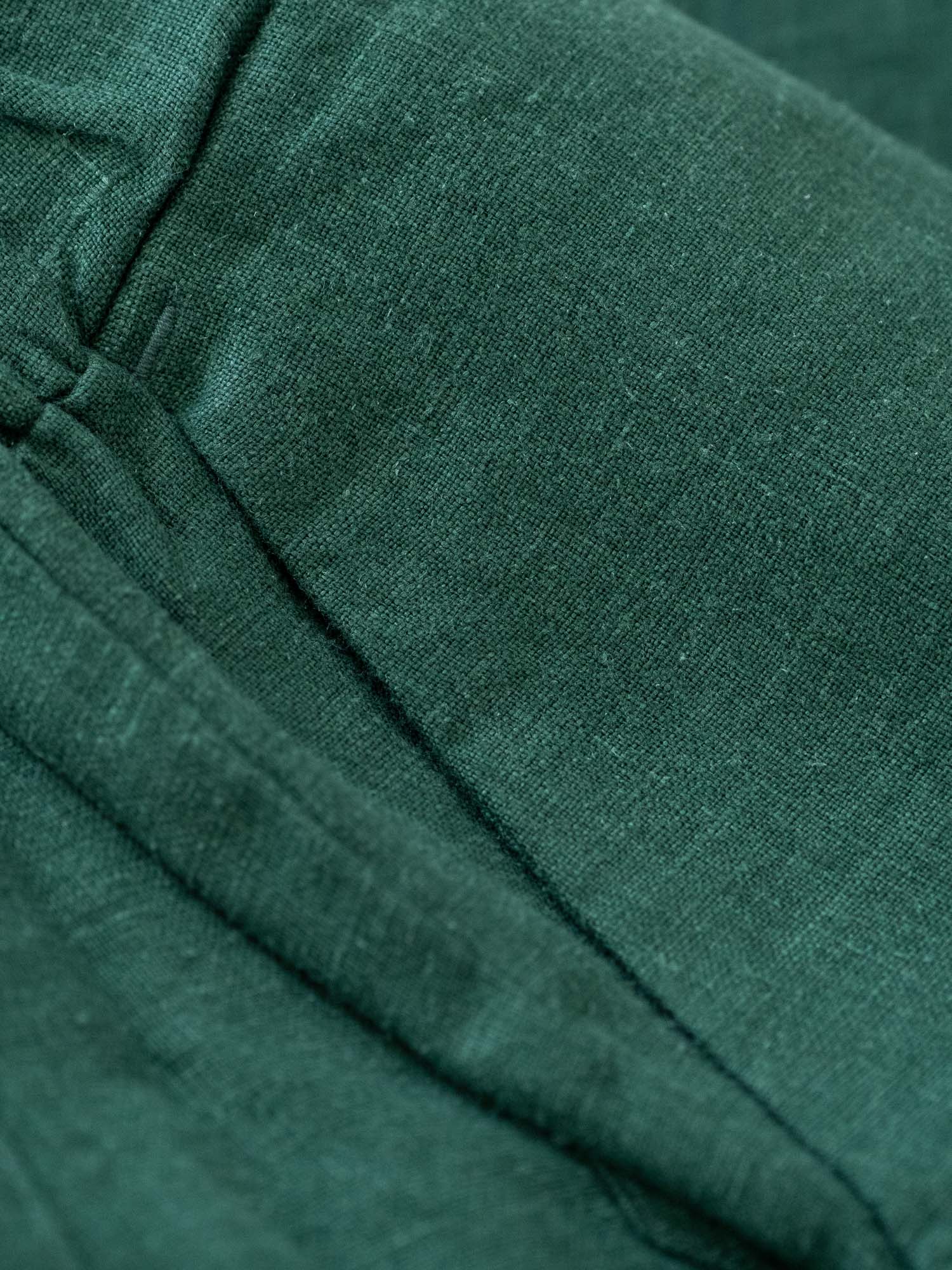 Detailbild einer Hosentasche der nachhaltigen FUXBAU Leinenkollektion in grün