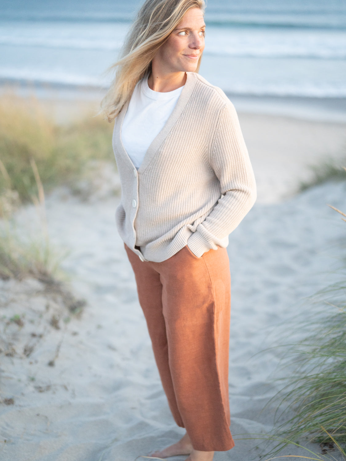 Nachhaltige Fair Fashion Frauen Sommer Leinenhose von FUXBAU in sienna rotbraun aus 100% Leinen gefertigt in Portugal. Getragen von Isi am Strand in Portugal.