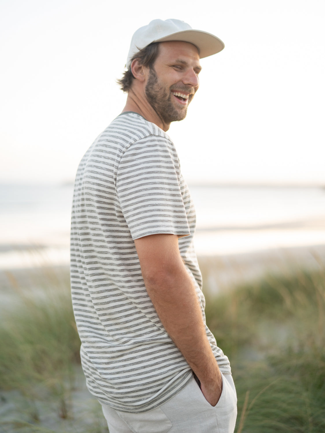 Philipp ist 1,95m groß und trägt das FUXBAU Männer fux Merida T-Shirt in beige grün meliert in der Größe XL und seitlicher Ansicht.