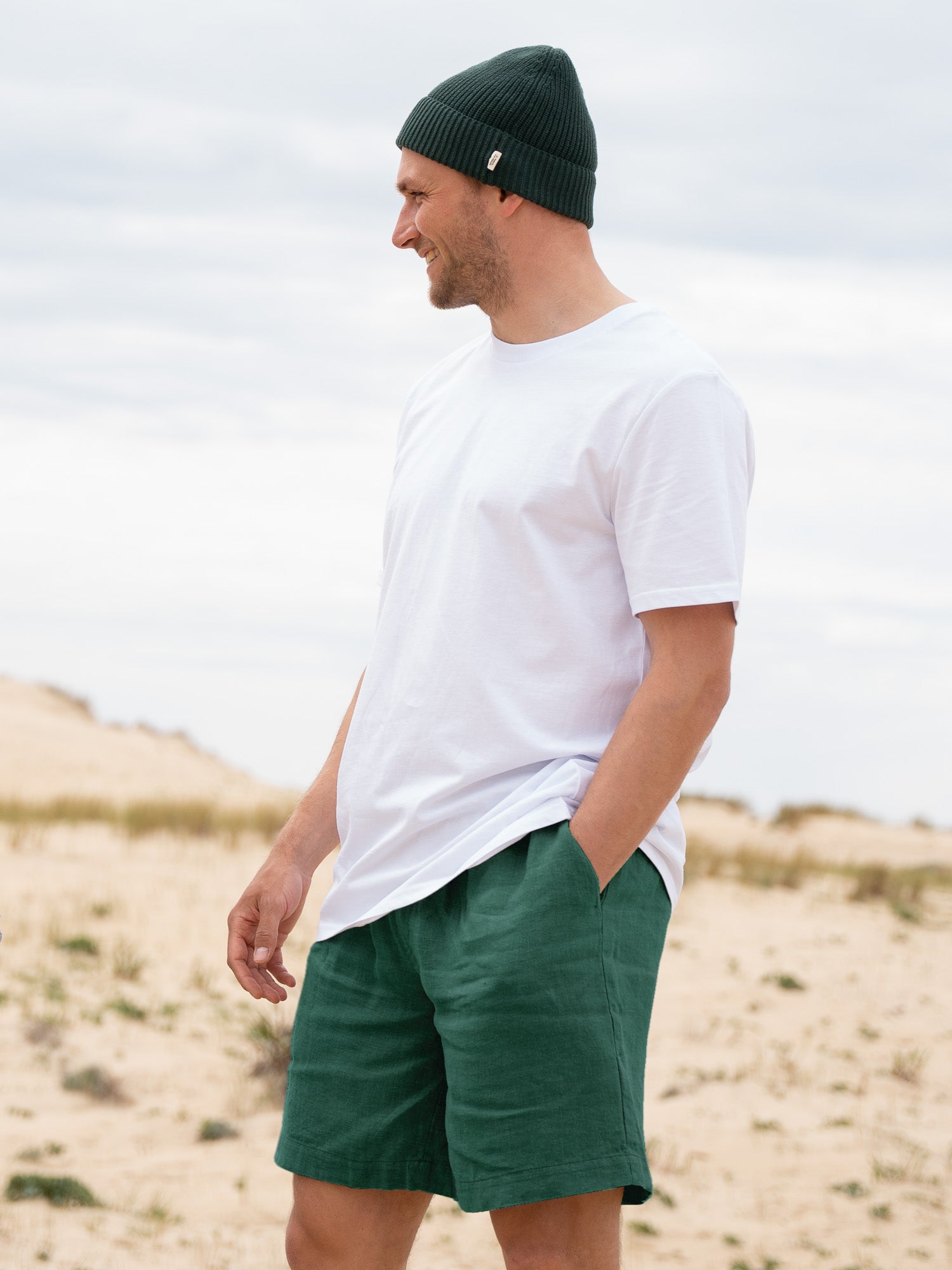 Fredde ist 1,85m und trägt "L" in der nachhaltigen und fairen FUXBAU Männer Leinenshorts in grün.