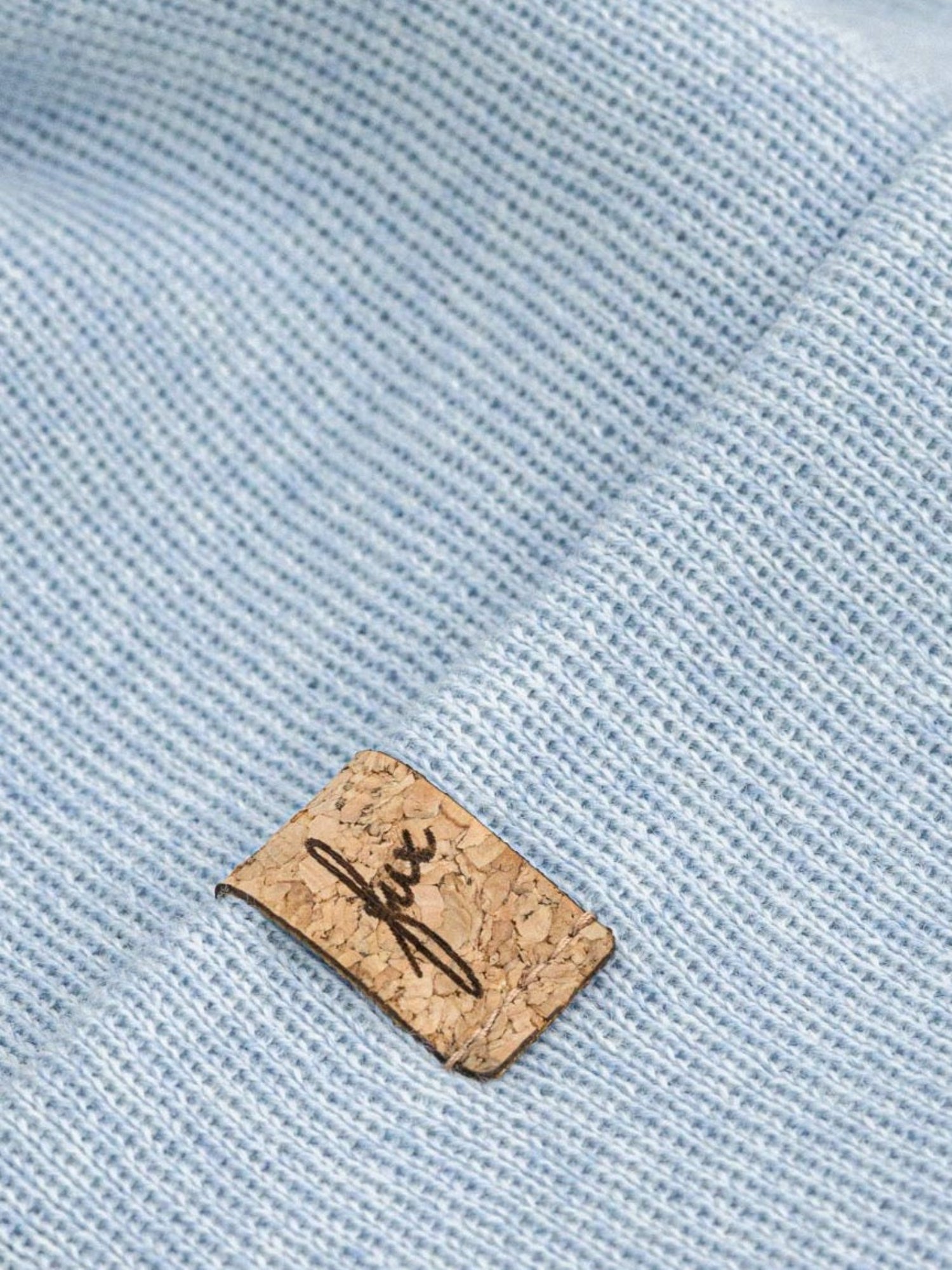 FUXBAU Fair Fashion Kinder Merino Kork Beanie in Eisblau mit hochwertigem Kork-Patch in der Detailansicht.