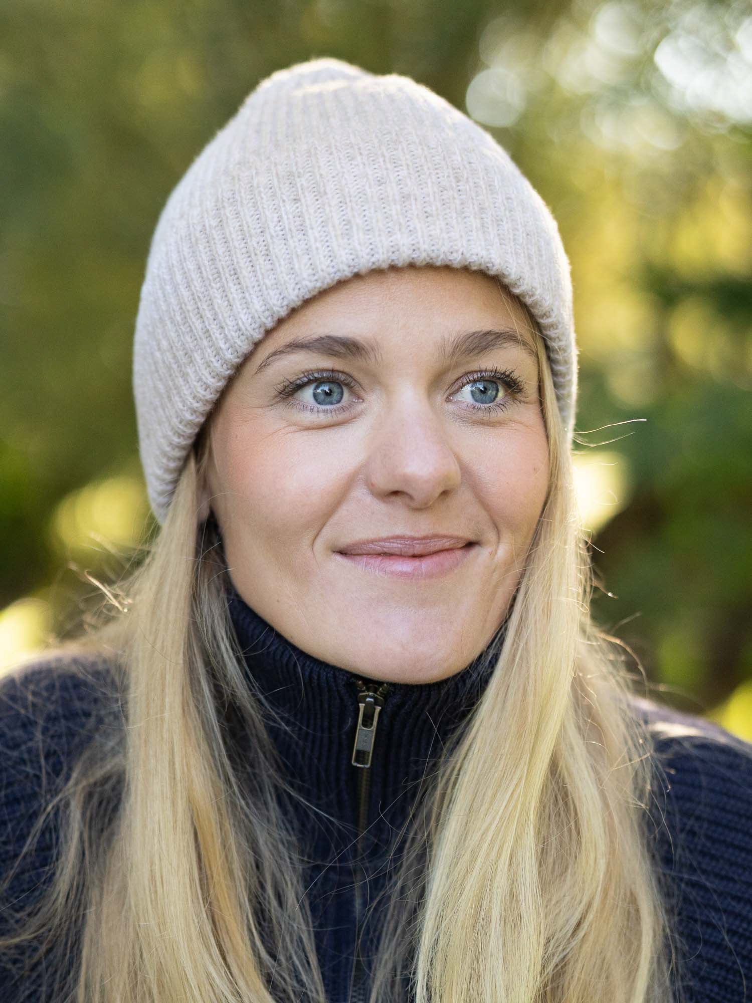 Greta trägt die FUXBAU Merino Mütze in Beigemeliert – weiche, natürliche Strickmütze aus italienischer Merinowolle, fair gefertigt in Deutschland