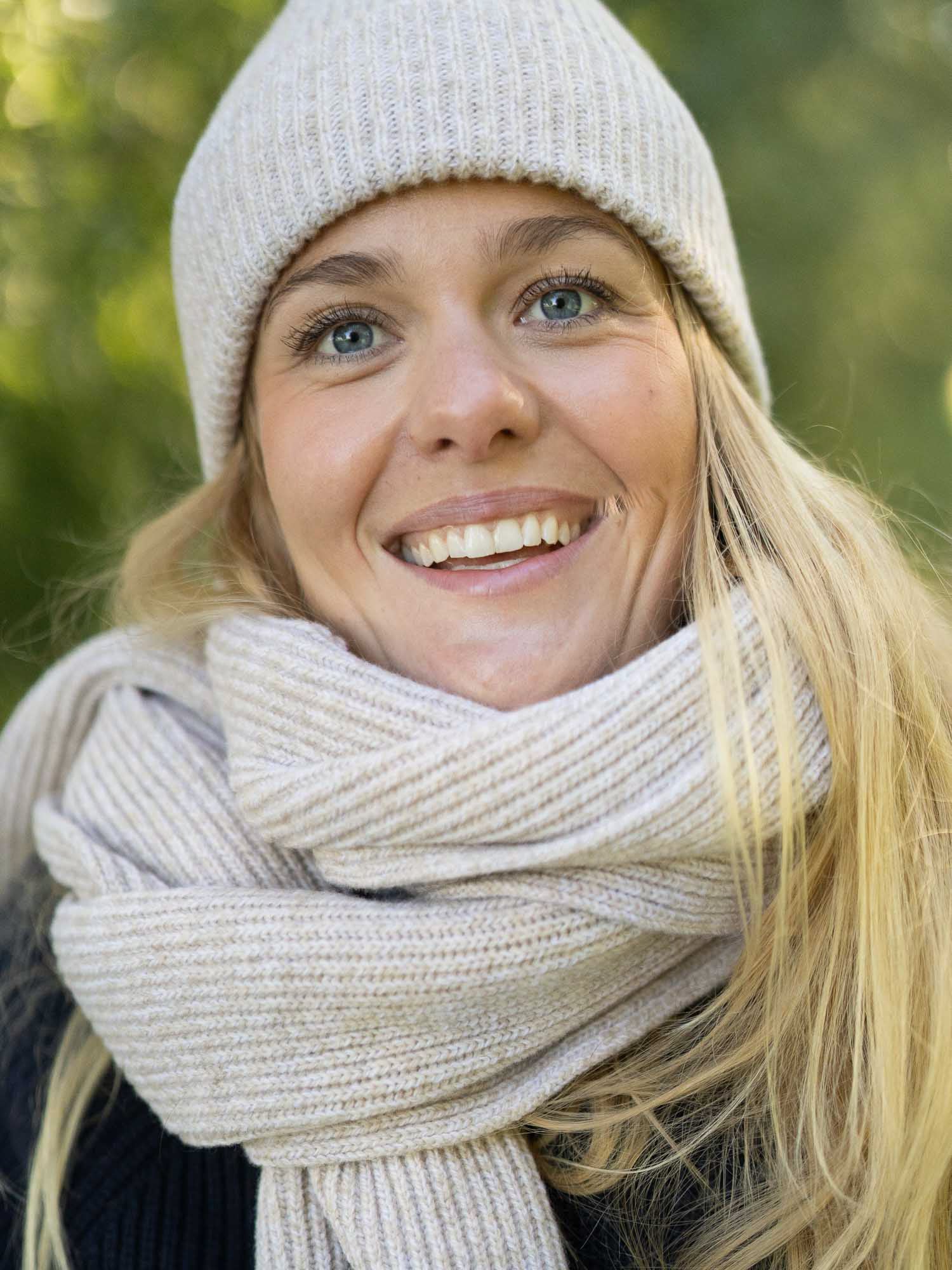 Nachhaltiger Merino-Schal extra lang in Beigemeliert mit beigemelierter Merino-Mütze – Fair-Fashion Outfit im Grünen.