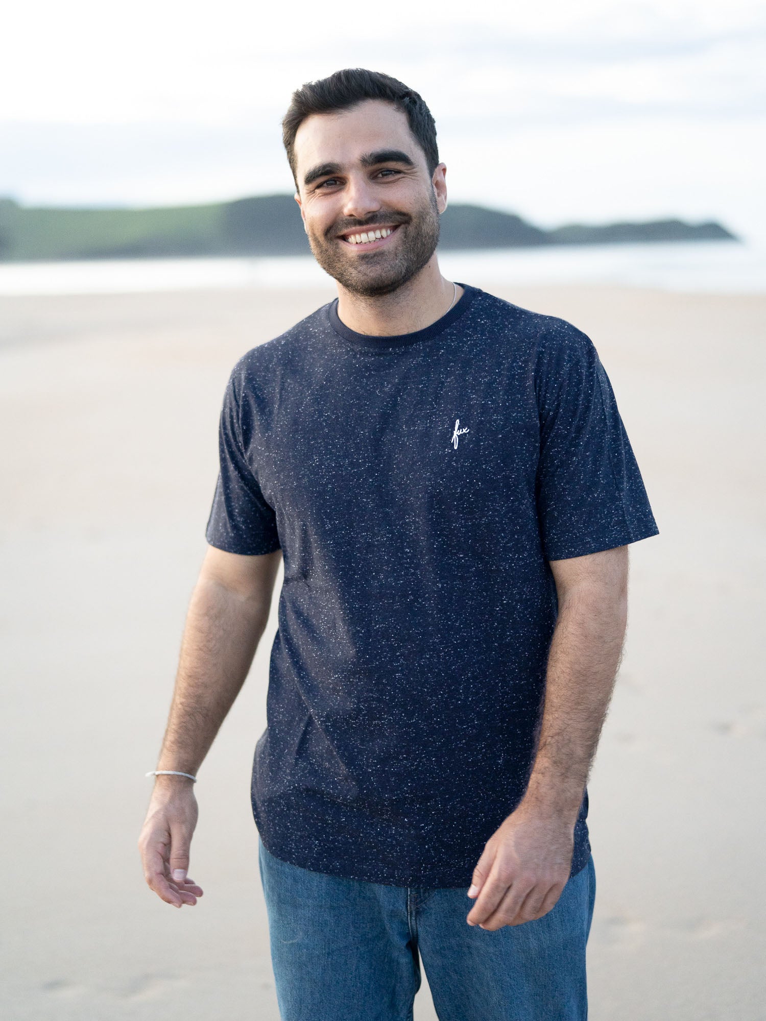 Unser Freund Guillermo trägt das nachhaltige Männer fux T-Shirt in navy mit kleinen weißen Neps am Strand