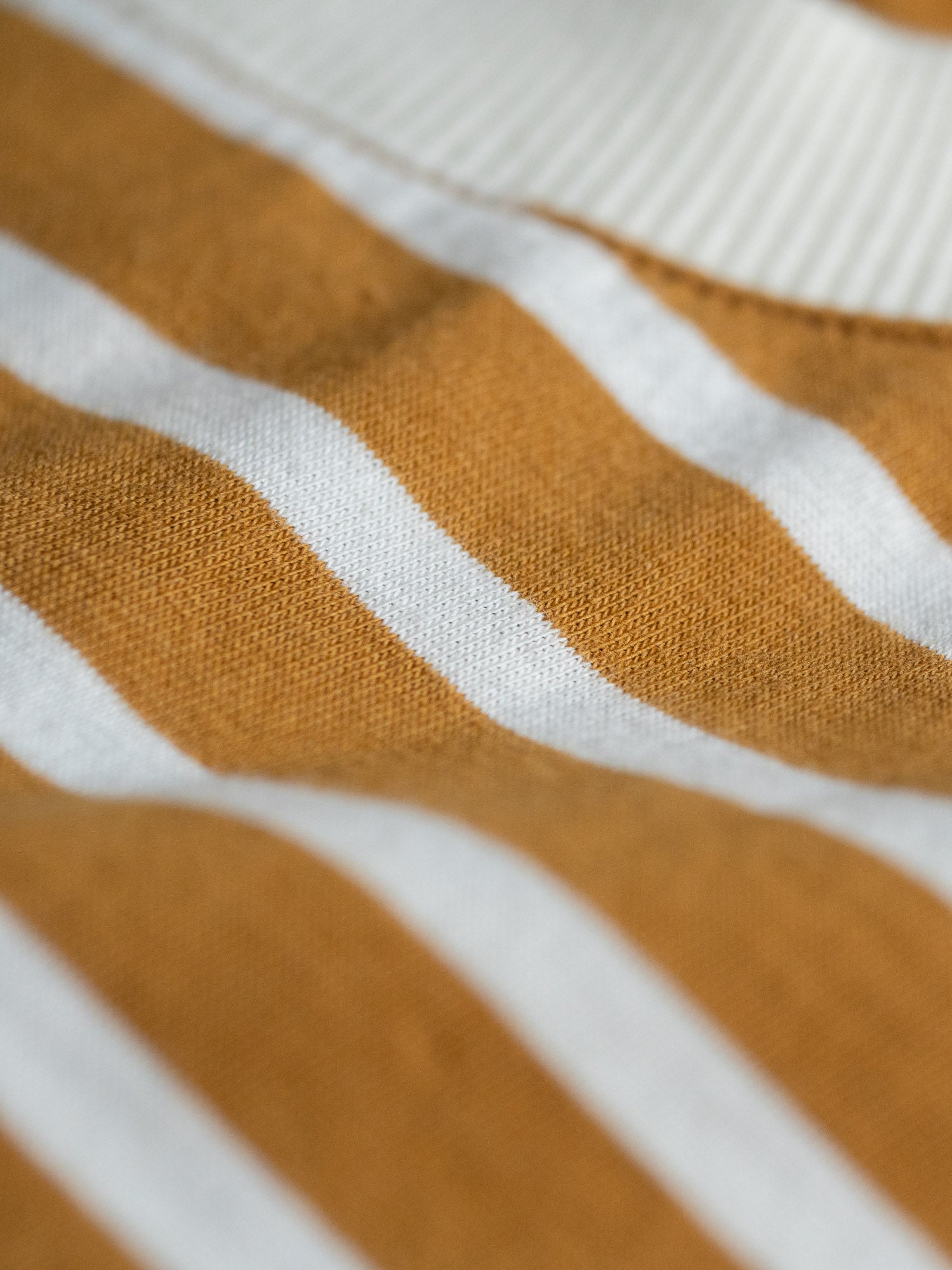 Detailansicht eines nachhaltiges Fair Fashion Frauen Streifen Longsleeve in creme senf aus 100% GOTS zertifizierter Biobaumwolle.