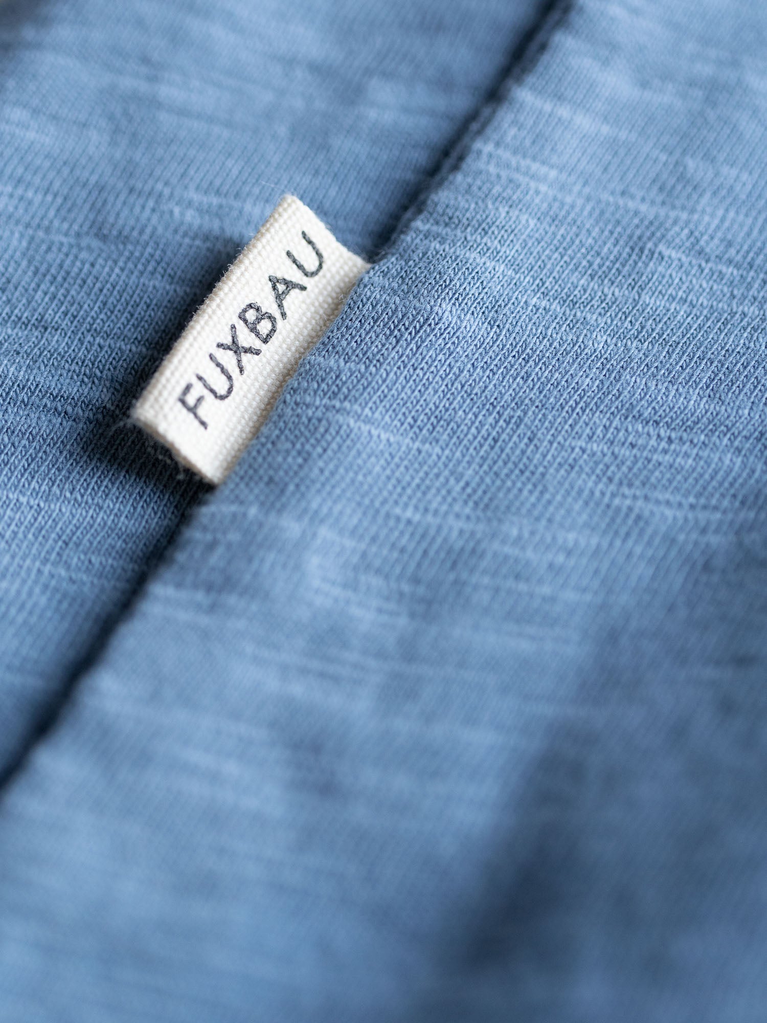 Detailansicht einer Sideflag in weiß vom nachhaltigen Fair Fashion Männer Azul T-Shirt von FUXBAU aus 100% GOTS Bio-Baumwolle.