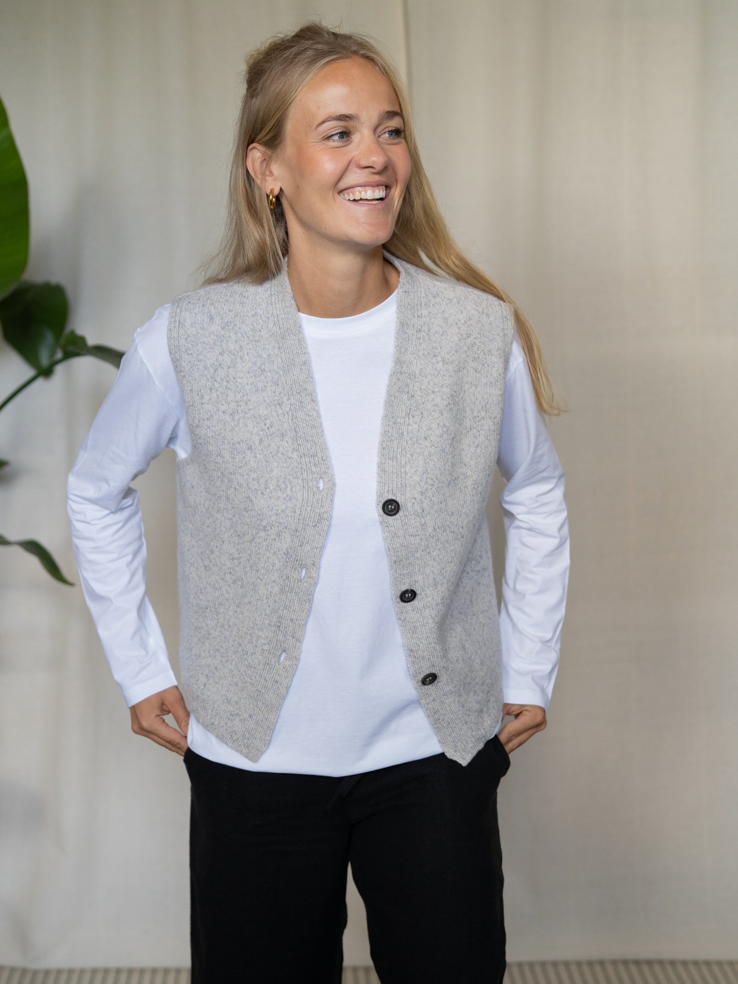 Frau trägt graumelierte FUXBAU Merino Strickweste – nachhaltige Damenweste aus weicher Merinowolle, gefertigt in Deutschland