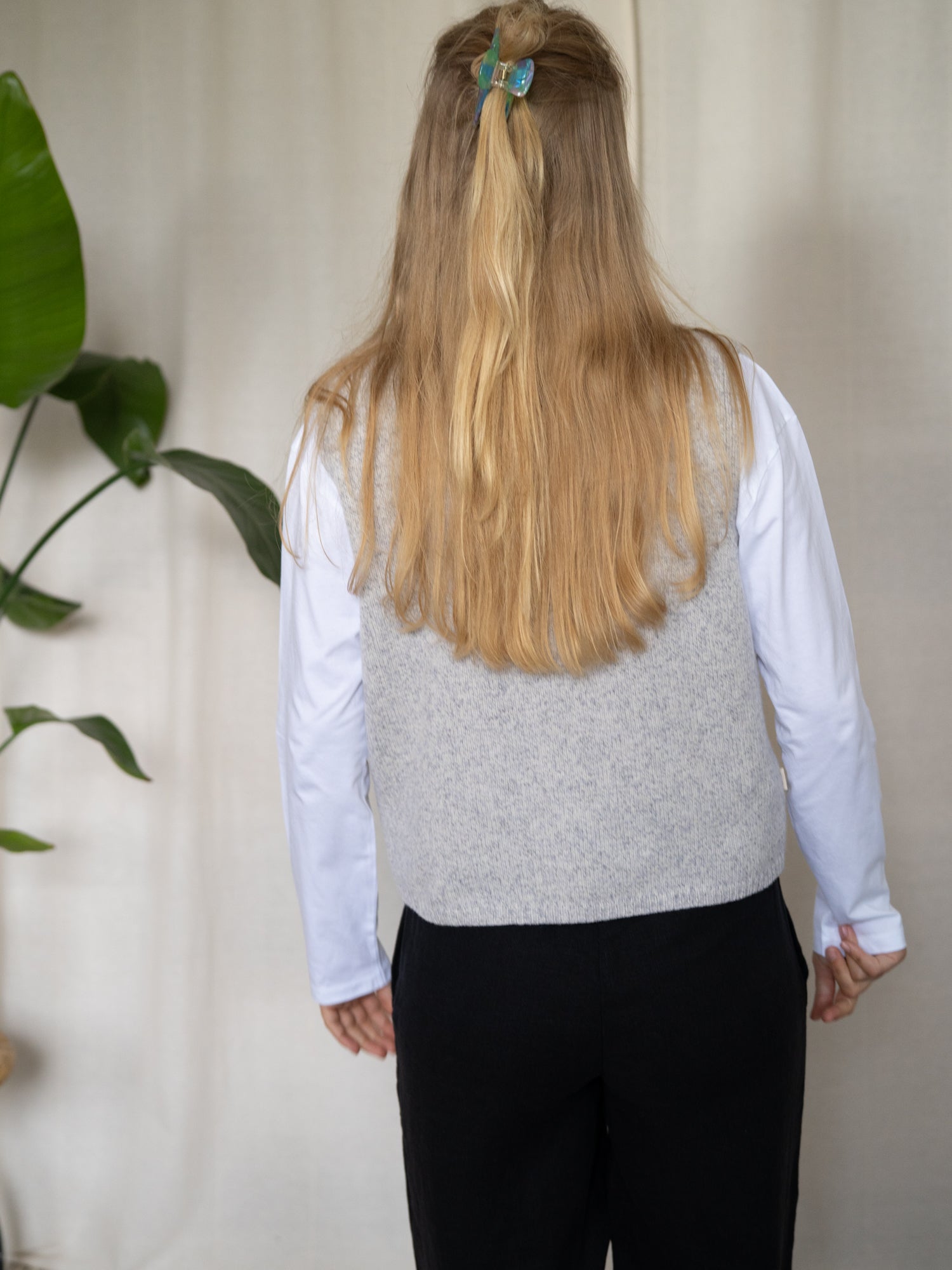 Rückansicht der FUXBAU Merino Strickweste Damen in Graumeliert – minimalistische, zeitlose Passform aus 100 % Merinowolle