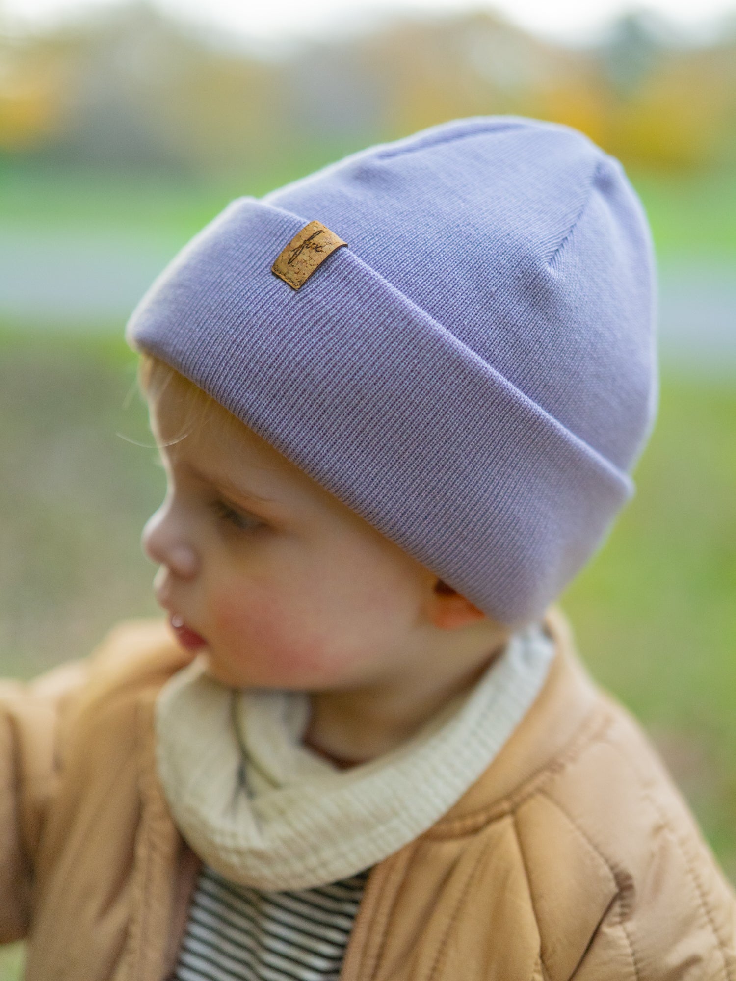 Kind trägt FUXBAU Kinder Beanie aus Merinowolle in Lavendel – nachhaltige Mütze mit Korklabel, fair gefertigt in Deutschland