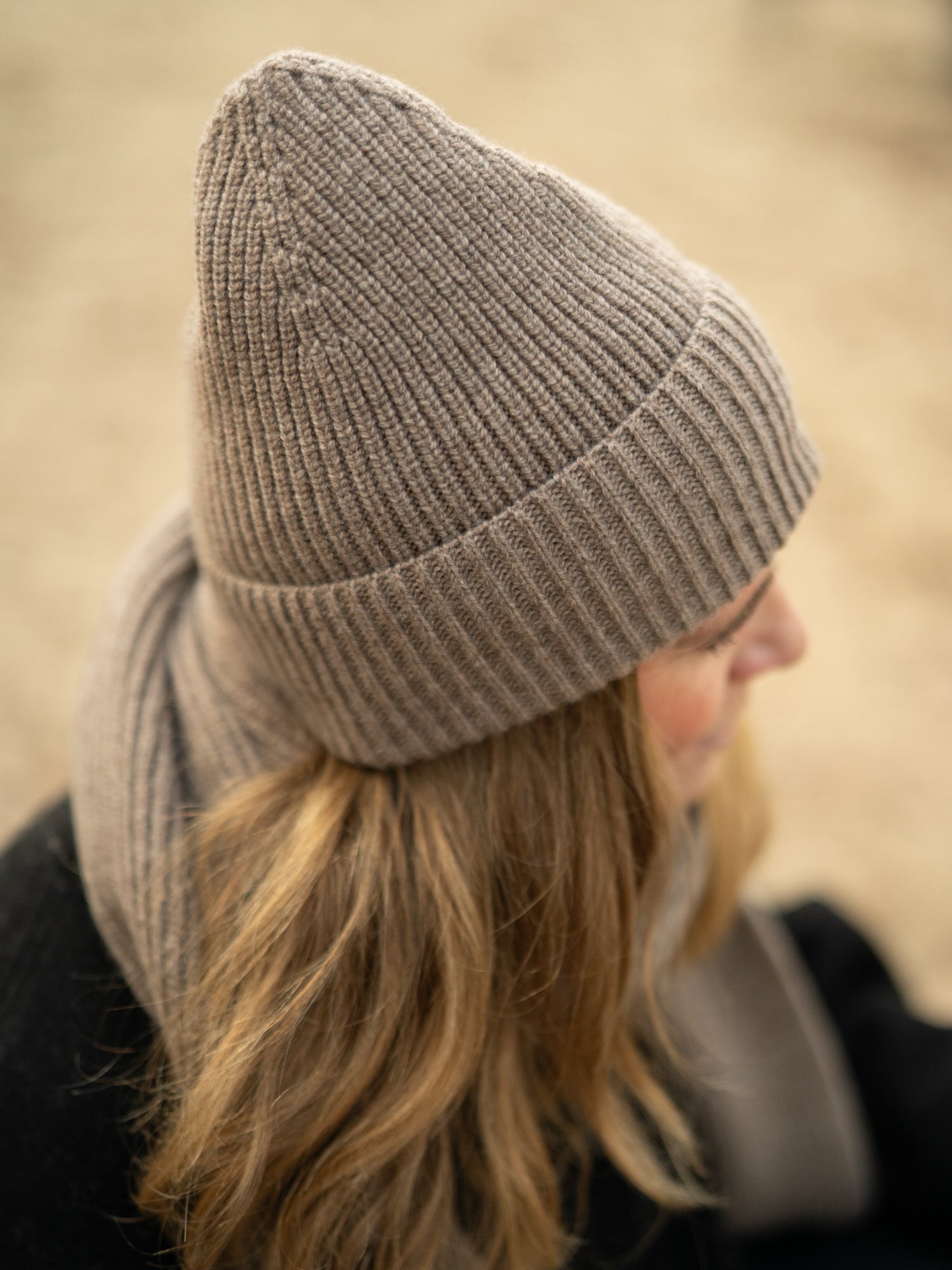 FUXBAU Merino Schal extra lang in braunmeliert – Detailaufnahme getragen, weiche Rippstruktur aus italienischer Merinowolle.