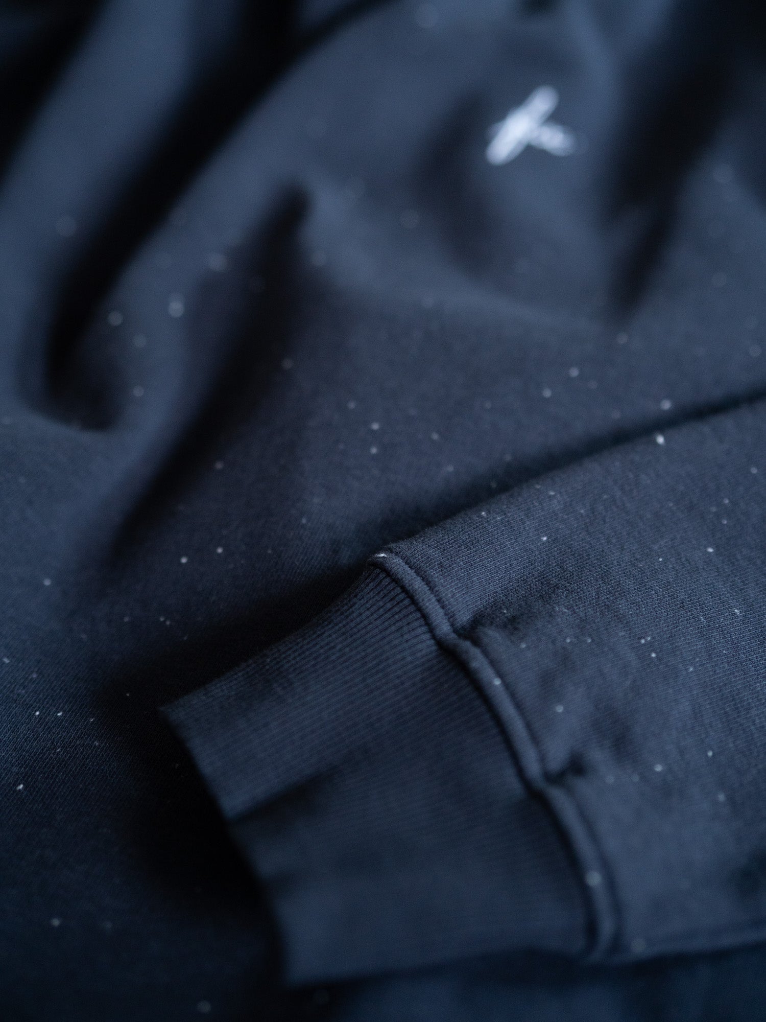 Ärmel-Detail des navyblauen FUXBAU Neps Pullovers aus GOTS-zertifizierter Bio-Baumwolle – hochwertiger Rippbund und dezentes FUX-Logo