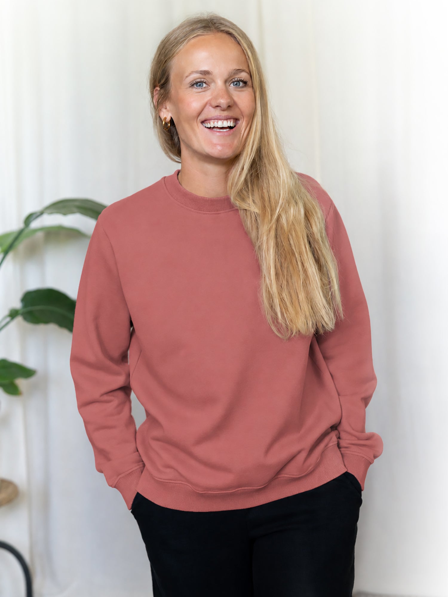 Greta trägt den nachhaltige Frauen Pullover in rot aus 100% Biobaumwolle und fair in Portugal hergestellt