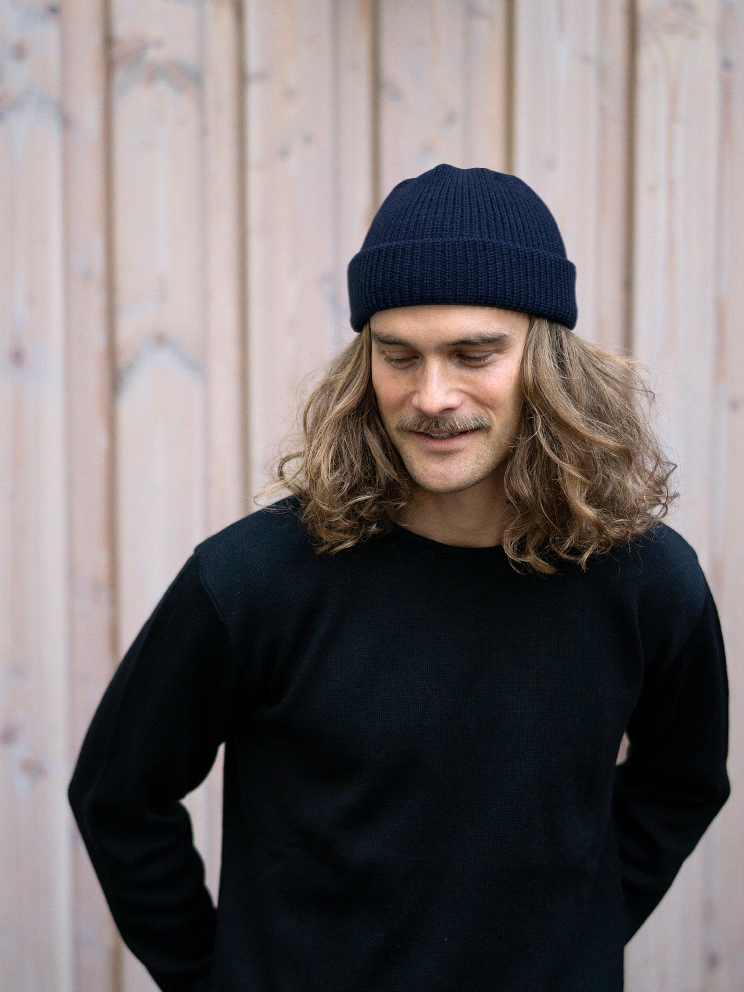 Unser Freund Kelsey trägt die Kurze Merino Strickmütze in navy von FUXBAU aus 100% GOTS zertifizierter Merinowolle made in Germany